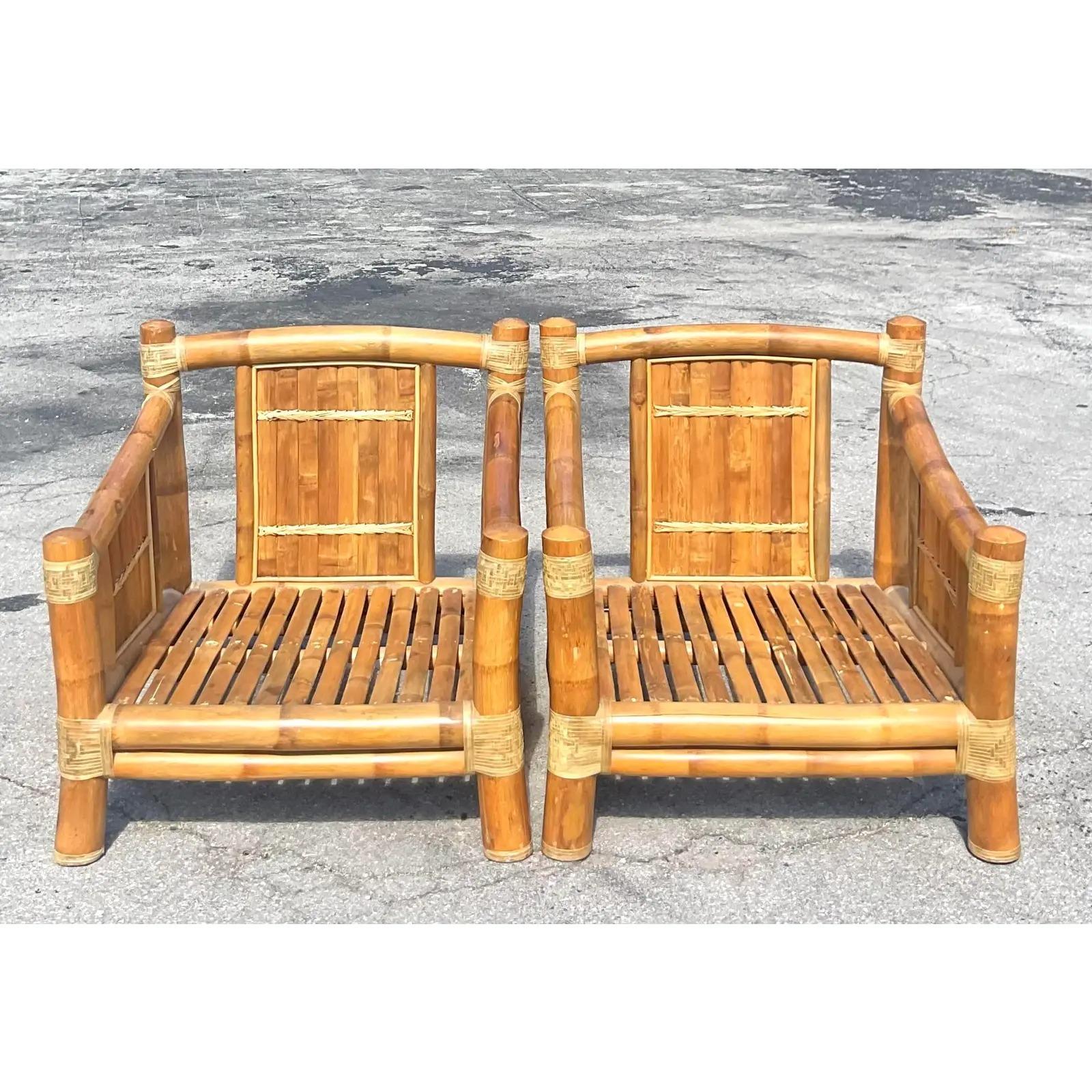Fantastic pair of vintage Coastal elephant bamboo lounge chairs. Thick bamboo creates this wide and comfortable frame. Chic palm print upholstery in great shape. Acquired from a Palm Beach estate.