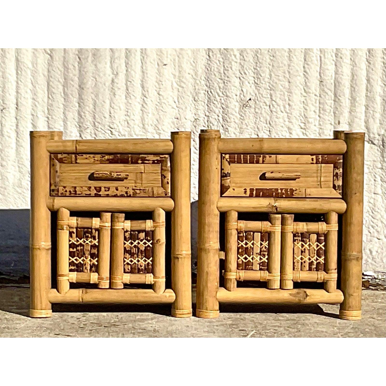 A fabulous pair of vintage Coastal nightstands. A chic elephant bamboo frame with inset split bamboo panels. Charming and dramatic. Acquired from a Palm Beach estate.