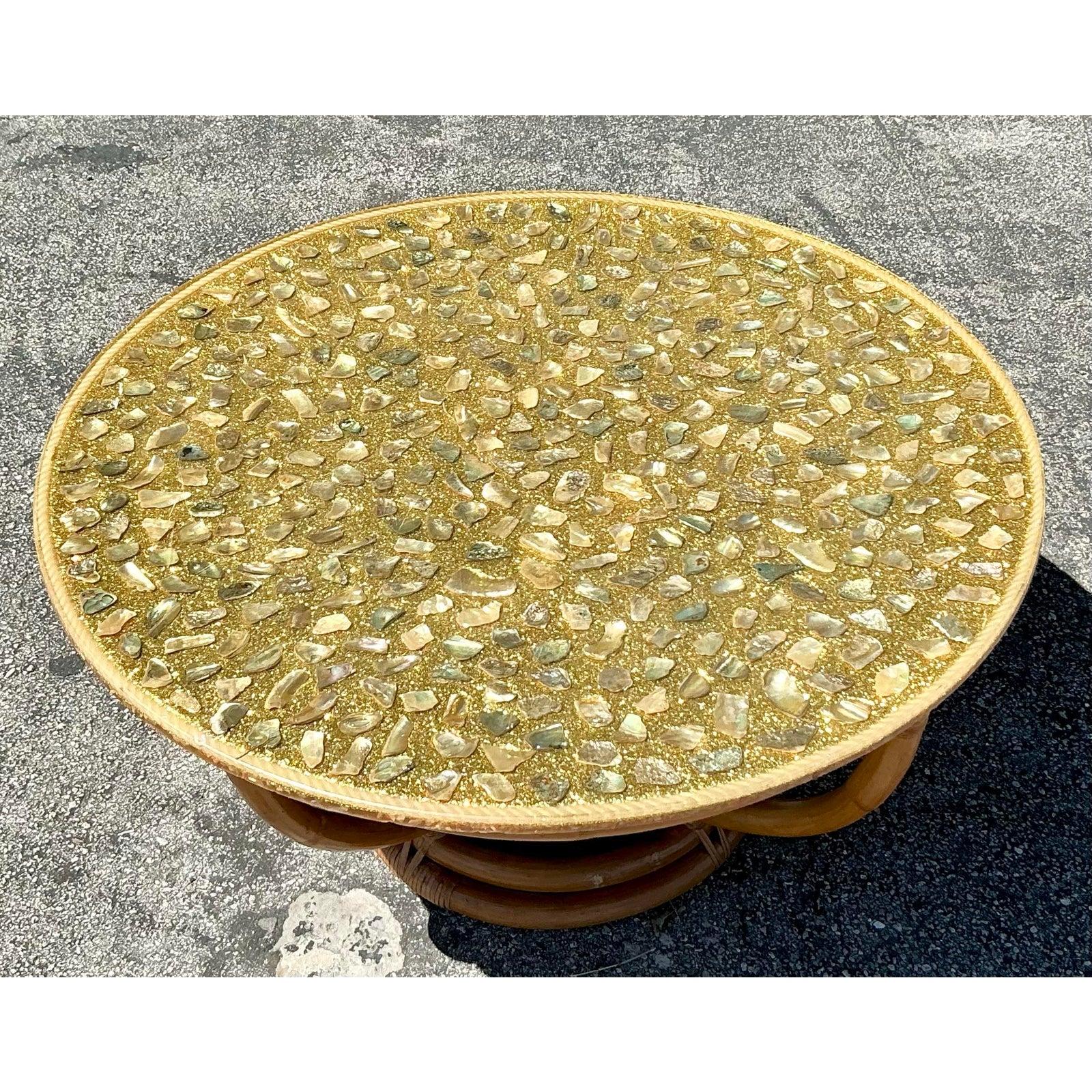Bring a touch of seaside charm to your space with this stunning vintage coastal coffee table. The beautifully crafted tabletop is embedded with an array of natural seashells and encased in a glossy resin finish, creating a mesmerizing, organic