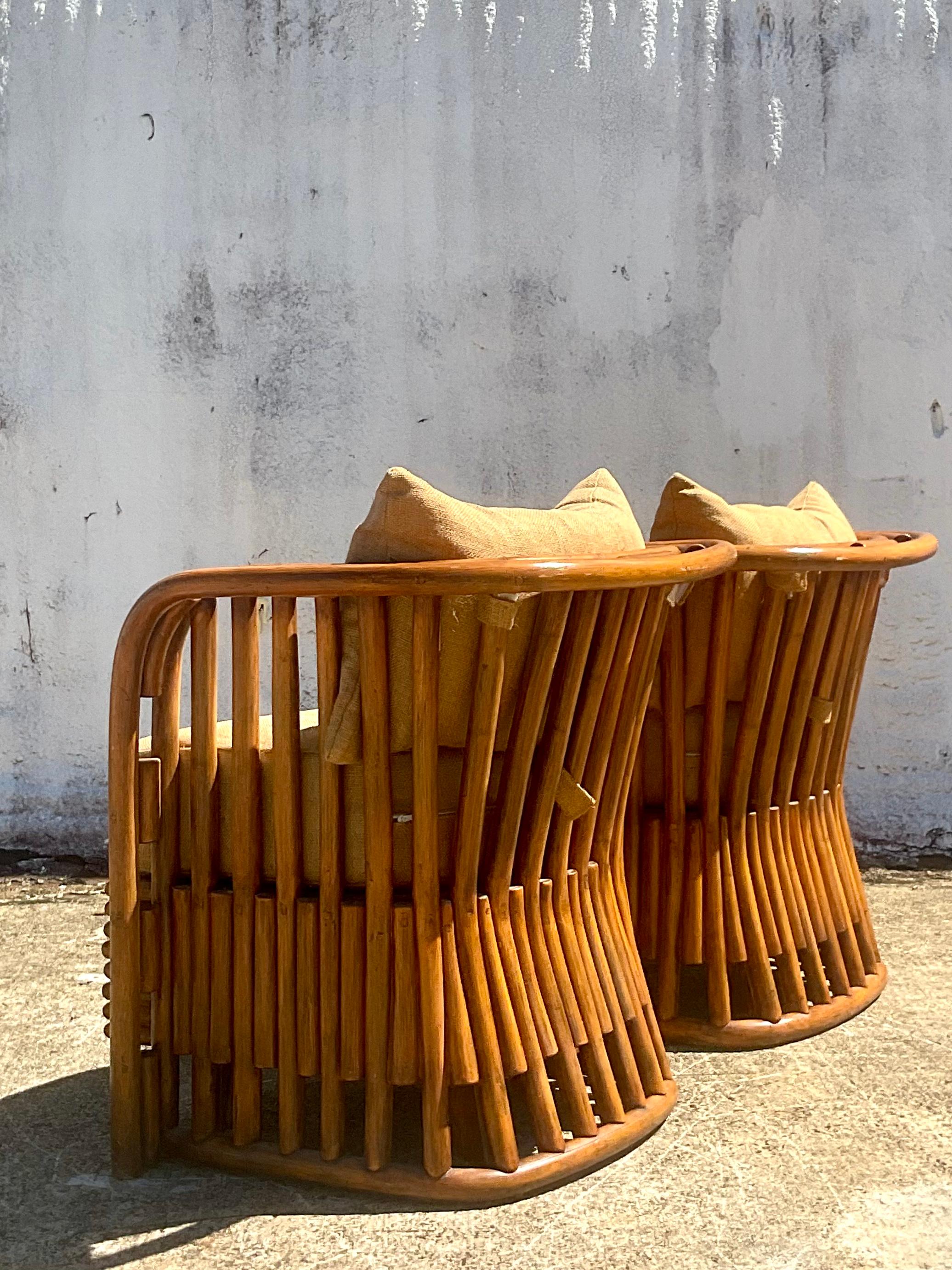 A fabulous pair of vintage rattan tub chairs. Made by the iconic Miami based Empire company. Beautiful curved shape with a chic heavy weave upholstery. Acquired from a Palm Beach estate.