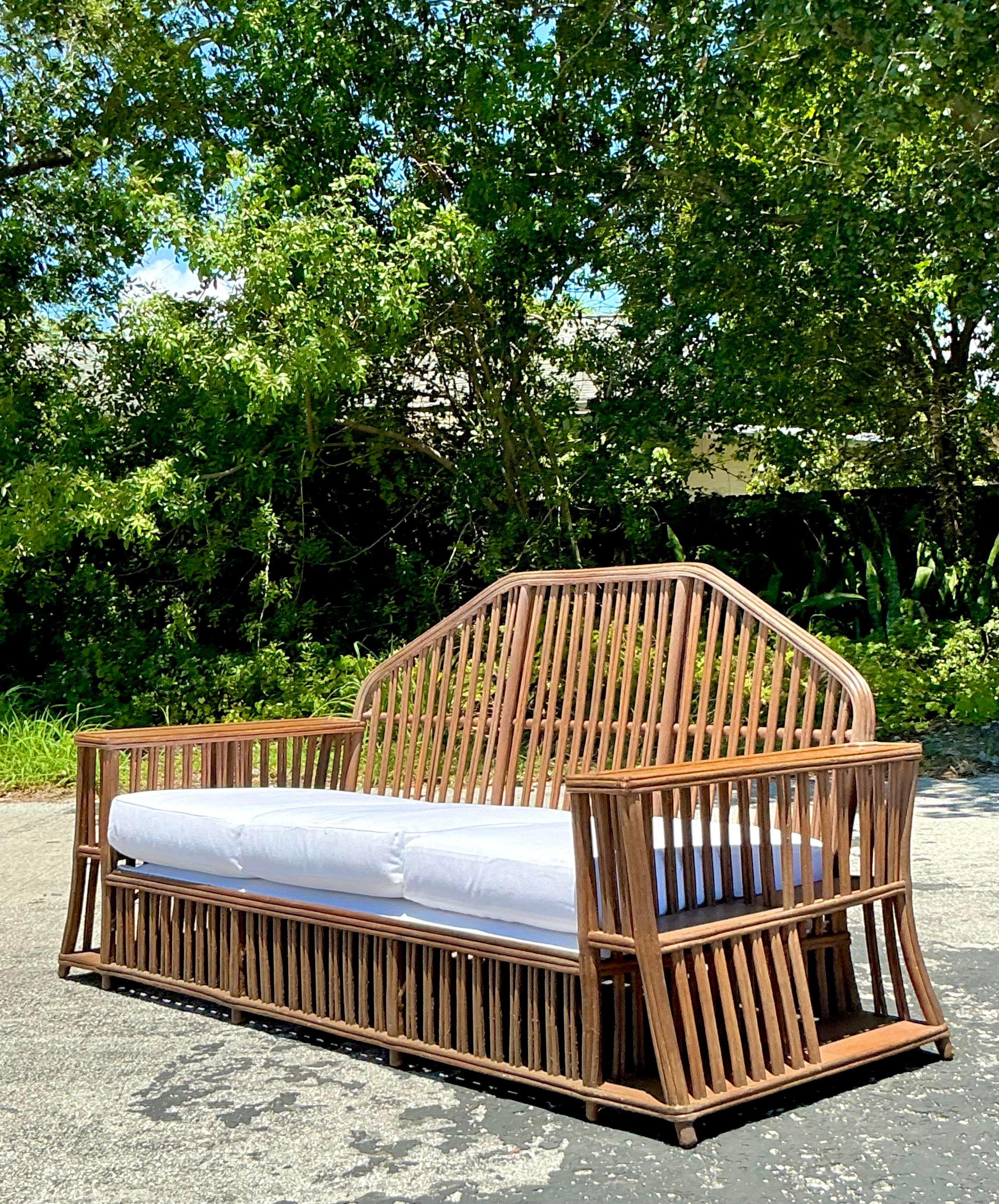 Ti presentiamo il nostro Divano in rattan sfaccettato in stile americano Vintage Coastal, ispirato agli iconici design di Heywood Wakefield. Realizzato con dettagli meticolosi e fascino costiero, è una dichiarazione di raffinatezza senza tempo per