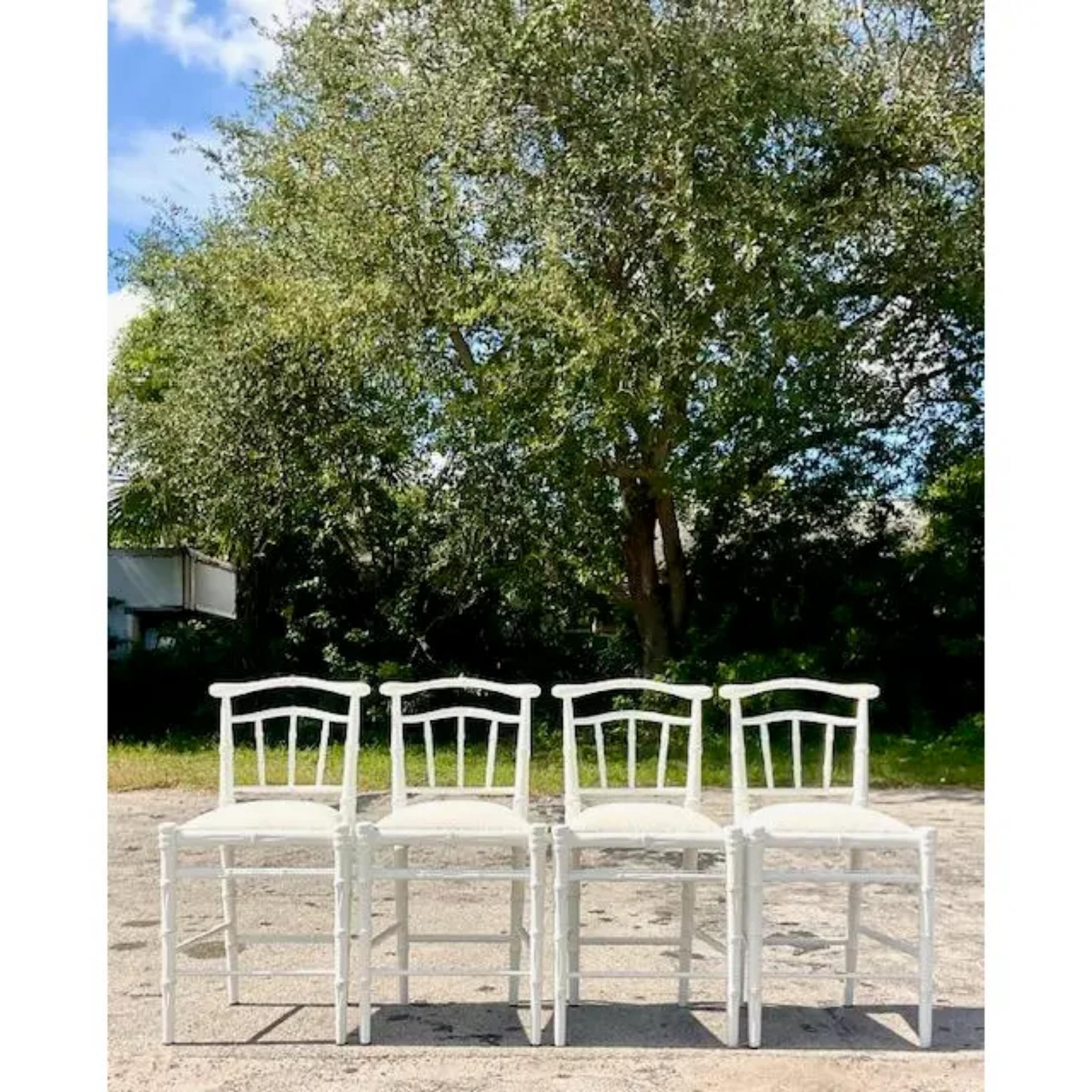 A fabulous set of four vintage Coastal bar stools. A chic faux bamboo design in a white finish. Acquired from a Palm Beach estate