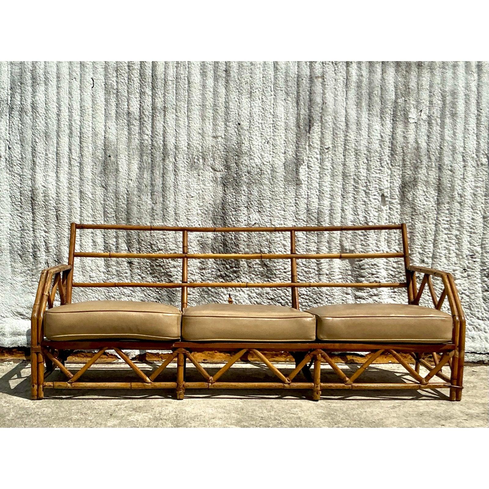 Infuse your space with timeless coastal charm through this vintage Ficks Reed bamboo sofa. Showcasing masterful craftsmanship, the handwoven bamboo frame features an intricate geometric lattice design that delivers natural elegance and textural