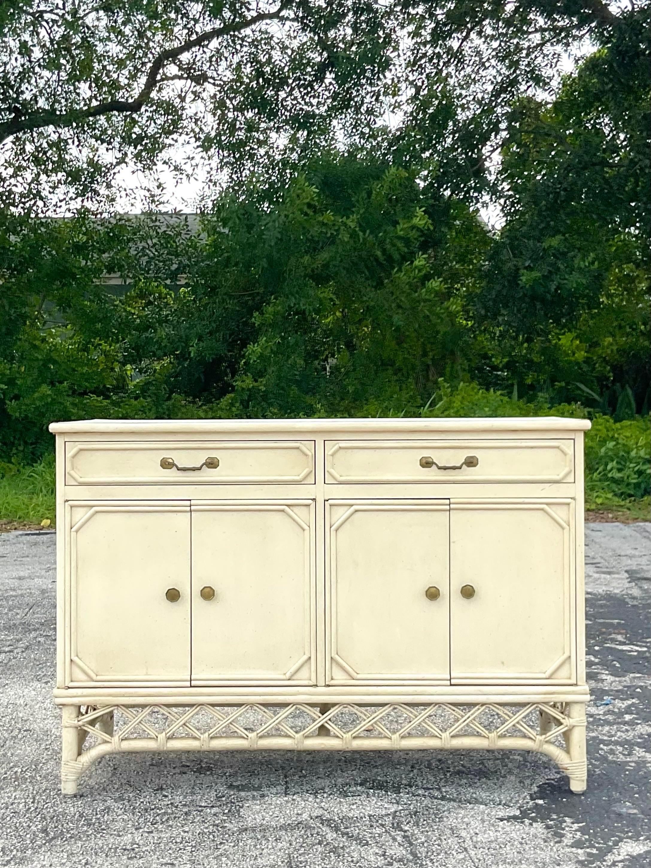 A fabulous vintage Coastal credenza. A chic wooden cabinet with rattan frame and lattice detail. Laminate top for extra protection. Signed on the inside drawer. Acquired from a Palm Beach estate.