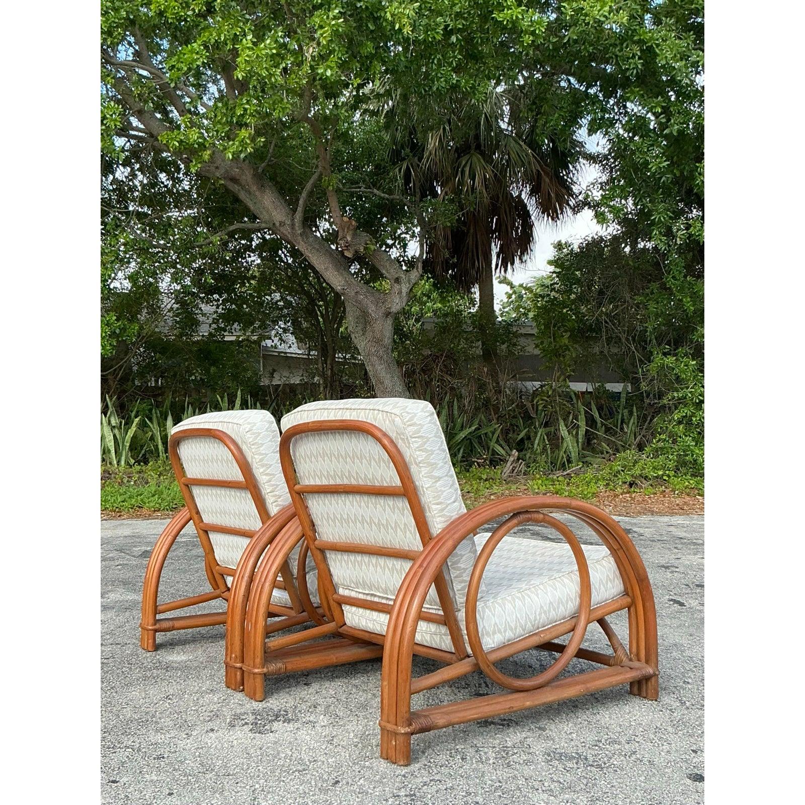 Bring a touch of coastal elegance into your space with this stunning pair of vintage Ficks Reed rattan lounge chairs. Showcasing beautifully curved rattan frames with a striking circular design, these chairs exemplify tropical sophistication and