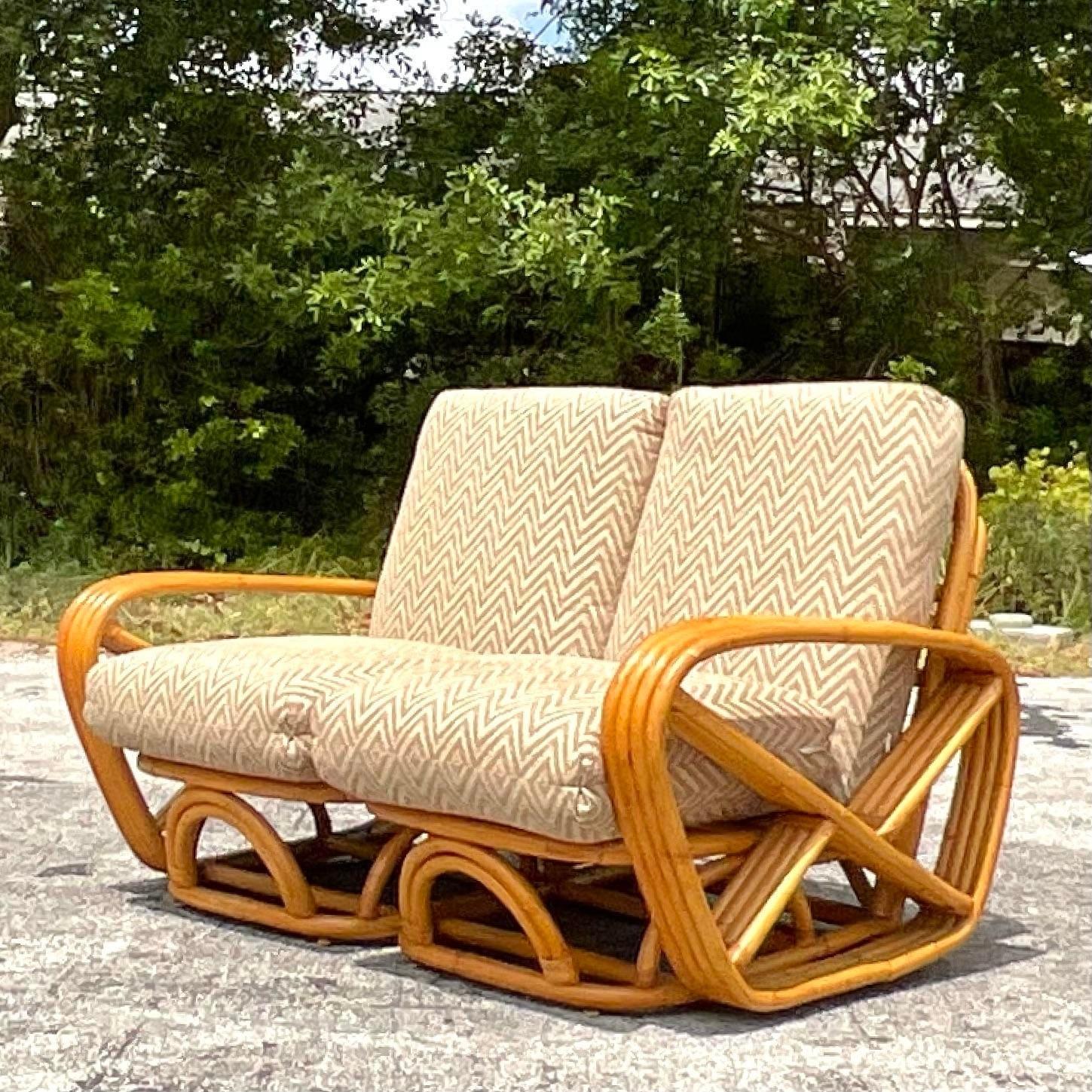 Embrace coastal sophistication with this Vintage Four Strand Bent Rattan Sofa, reminiscent of iconic designs by Frankl. Crafted with American flair, its elegant four-strand construction and natural rattan weave offer a timeless blend of comfort and