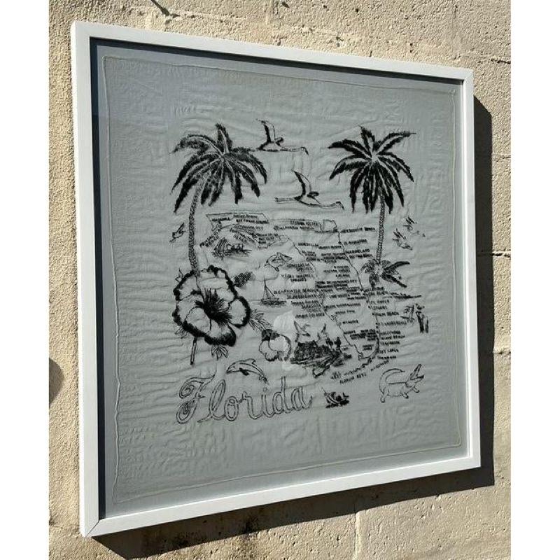 Celebrate the charm of the Sunshine State with this vintage Florida map textile art, beautifully framed in a crisp white border. The monochromatic design features intricate hand-drawn elements, including palm trees, seagulls, and iconic coastal