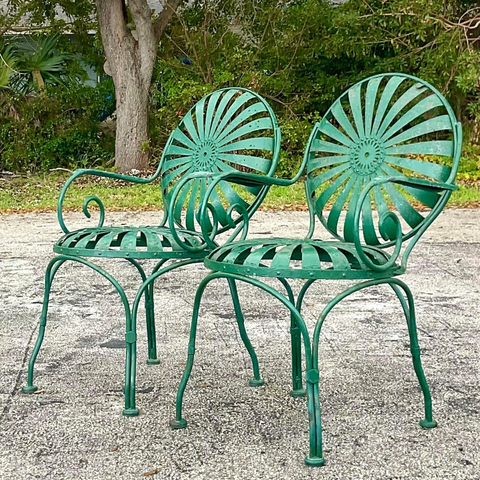 A fabulous pair of vintage Coastal arm chairs. Made by the iconic Francois Carre. Unmarked. His famous Sunburst design with radiating spokes. Acquired from a Palm Beach estate.