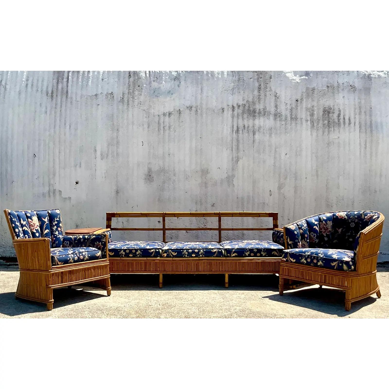 A spectacular vintage Coastal sofa. A beautiful French Art Deco design with a frame of pencil reed and a fully upholstered seating area. Matching chairs and side tables also available. Acquired from a Palm Beach estate.