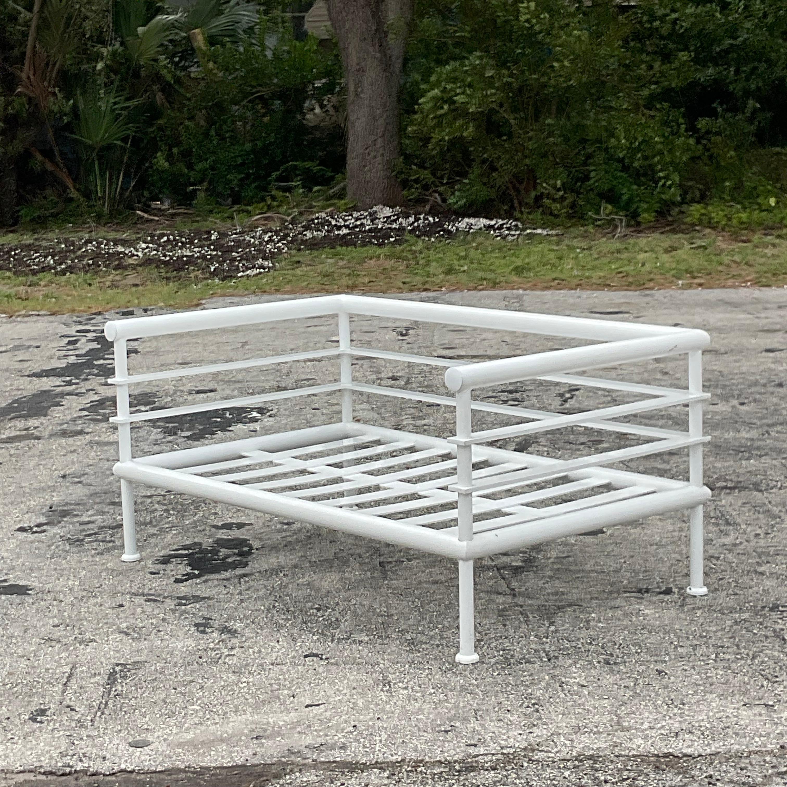 A stunning set of 4 vintage Coastal outdoor pieces. A chic sofa set that includes one sofa, two chairs and coordinating glass coffee table. Made by the exclusive French brand Hugonet and tagged on the back. A painted aluminum tubular frame