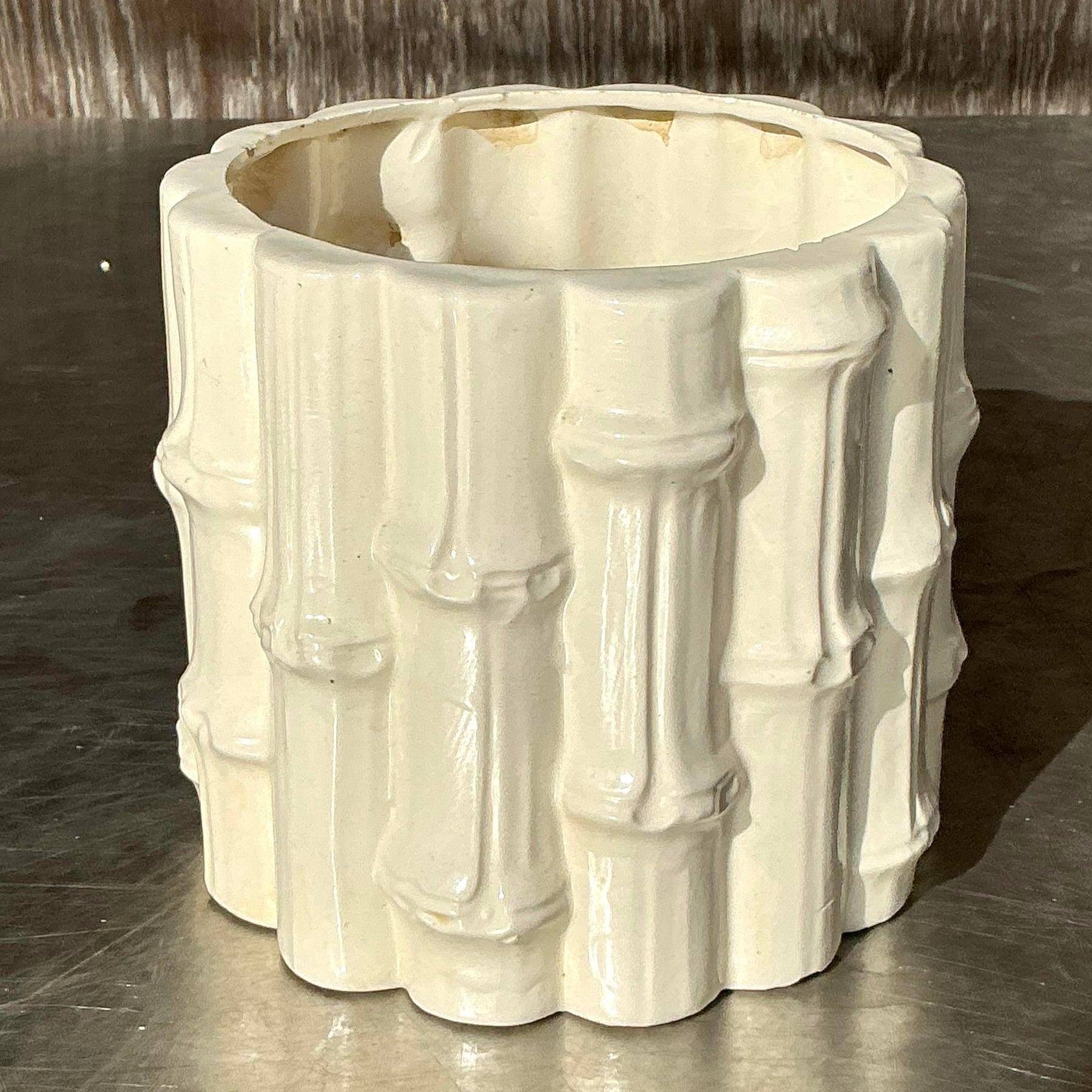 Vintage coastal glazed ceramic bamboo cache pot. This charming piece features a bamboo-inspired design with a glossy glazed finish, blending natural textures with coastal elegance. Perfect for showcasing plants, florals, or as a standalone decor