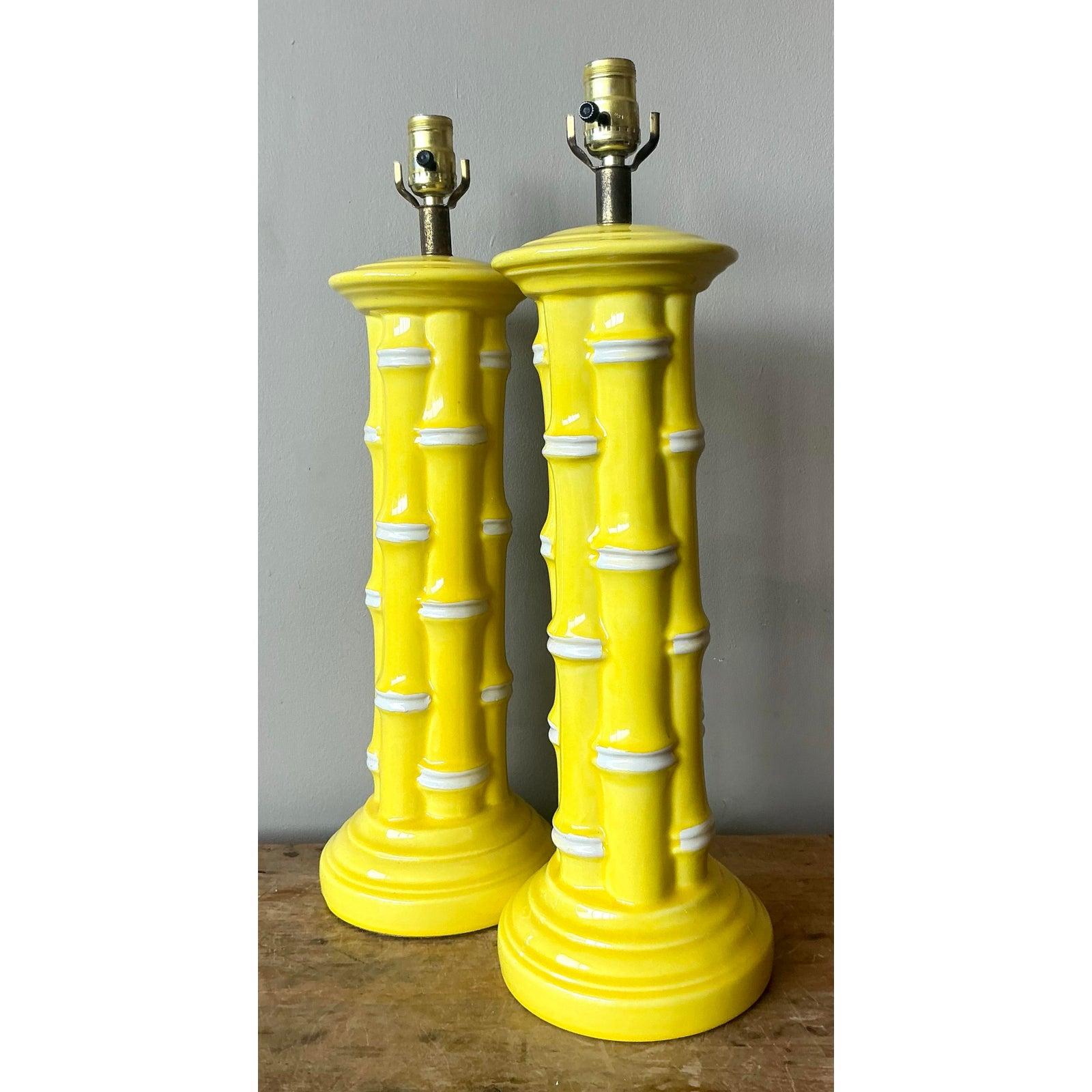 Este exuberante par de lámparas de mesa vintage es toda una declaración de estilo con su brillante y saturado esmalte amarillo limón. Los cuerpos de cerámica están esculpidos para imitar haces de tallos de bambú, con bandas blancas que simulan los