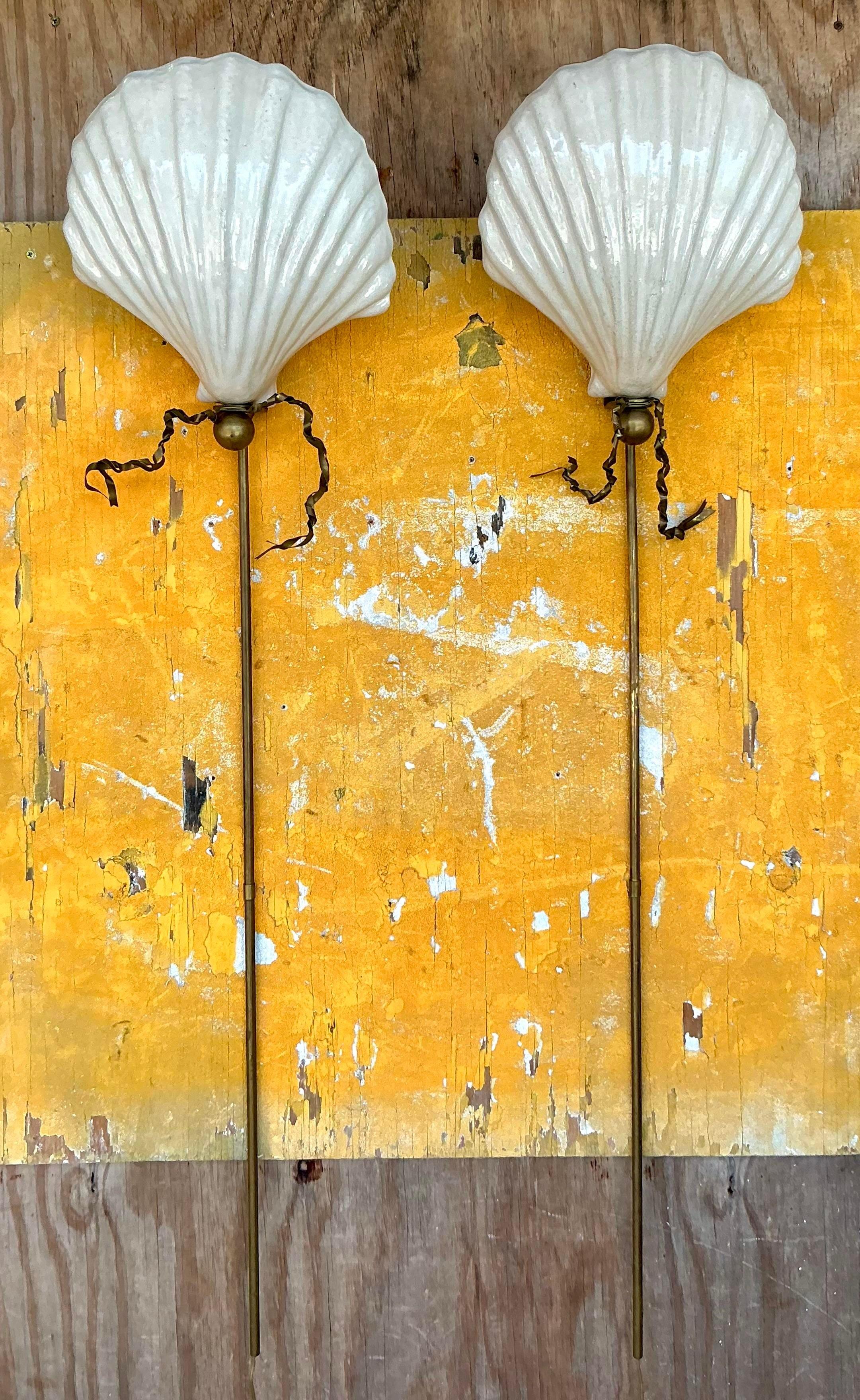 Bringen Sie einen Hauch von Küstencharme an Ihre Wände mit diesem Paar Vintage Coastal Glazed Ceramic Clam Shell Sconces. Ihr elegantes Muschelschalen-Design und die glasierte Oberfläche verleihen jedem Raum ein stilvolles und nautisches Flair.