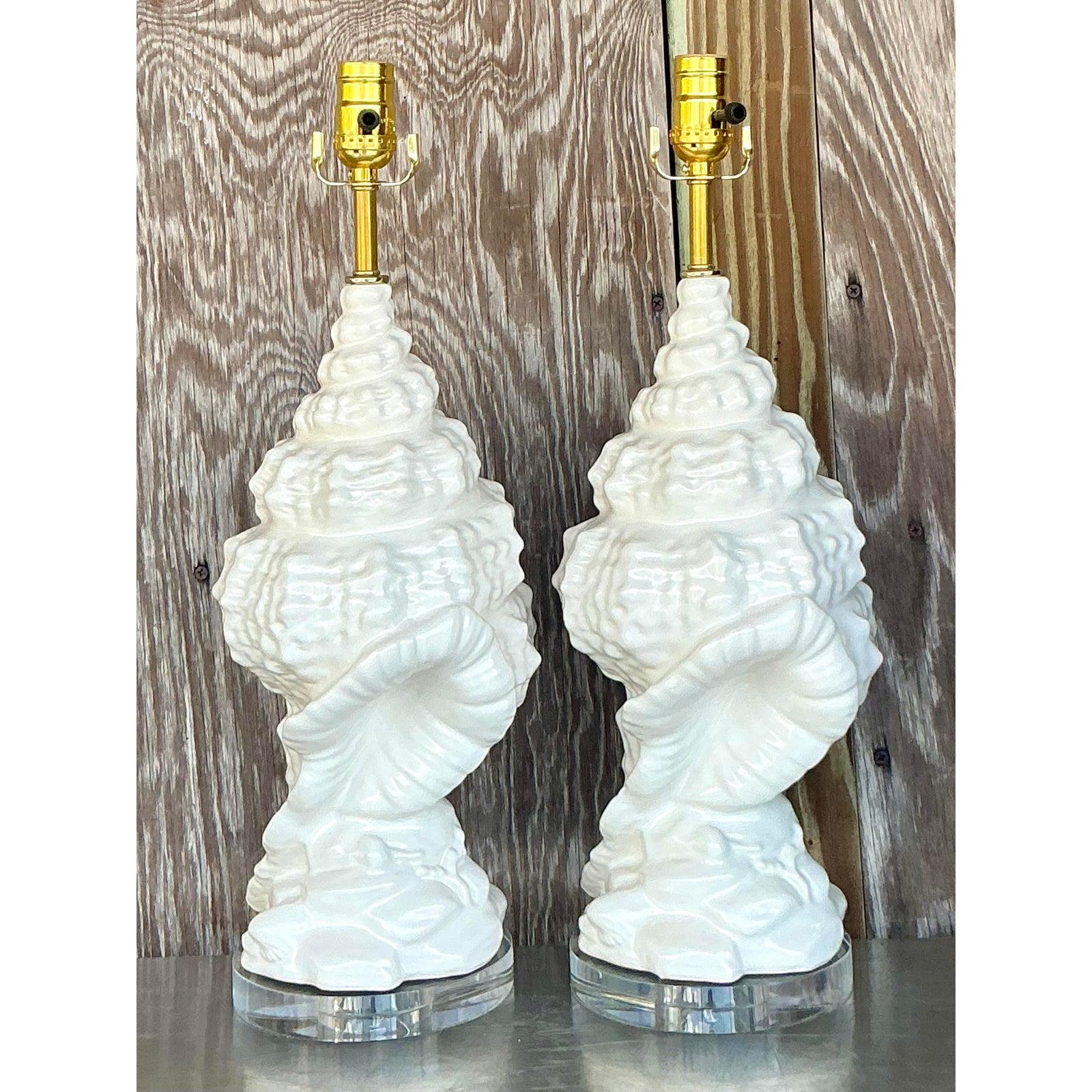 Bring the serene elegance of the seaside into your home with this exquisite pair of Vintage Coastal Glazed Ceramic Conch Lamps. Each lamp is meticulously sculpted to capture the intricate beauty and graceful curves of a natural conch shell, rendered