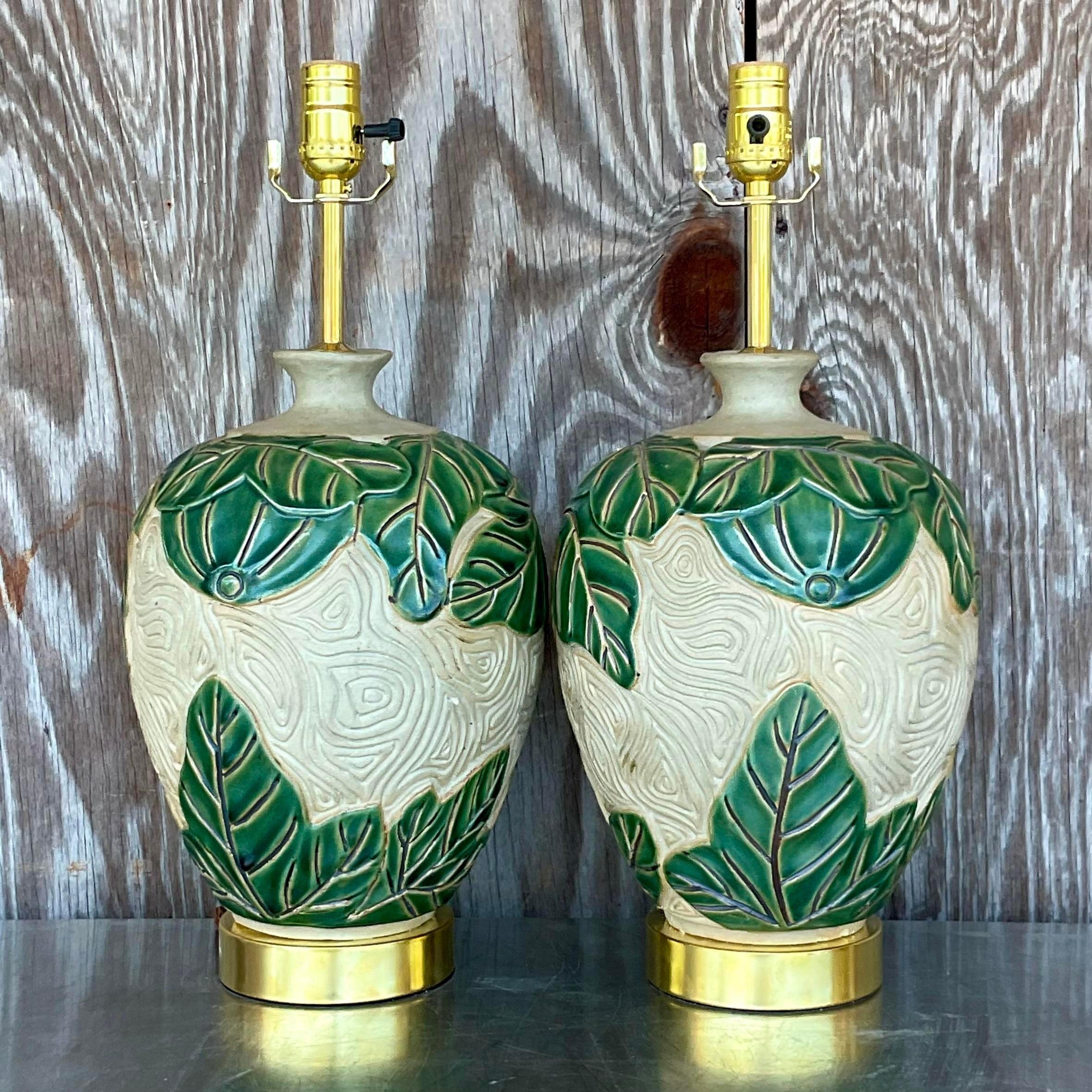 A fabulous pair of vintage Coastal table lamps. A chic tropical leaf design with a combo of glazed and matte finishes. Fully restored with all now hardware and wiring and gilt plinth. Acquired from a Palm Beach estate.