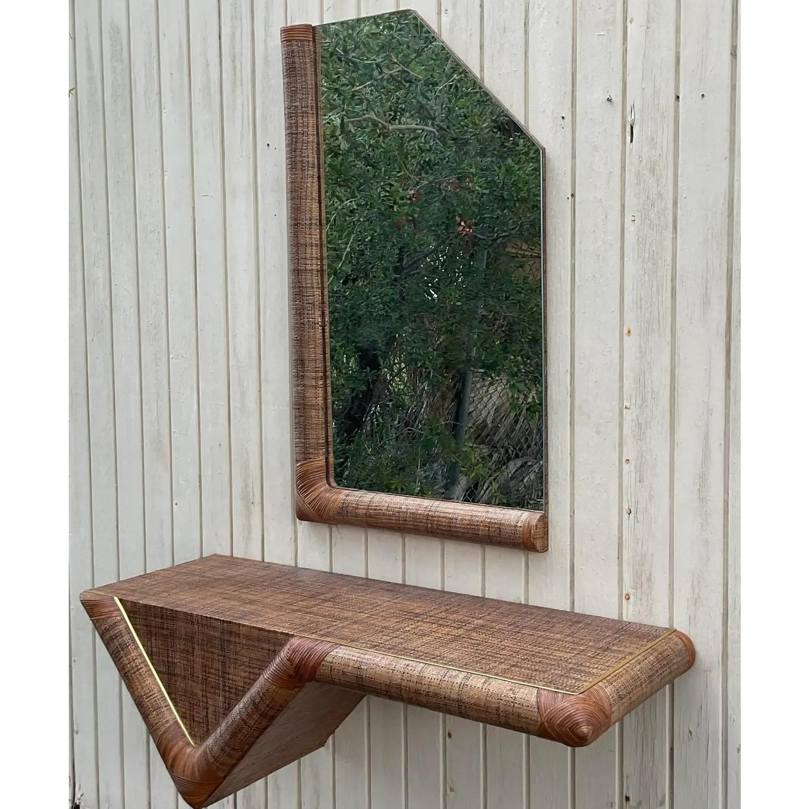 A fantastic vintage console table and mirror. Both pieces have the distinctive look made popular by Karl Springer. A chic Grasscloth finish with thin hair wrapped rattan edges. Acquired from a Miami estate.

Mirror dimensions - 25 x 42.