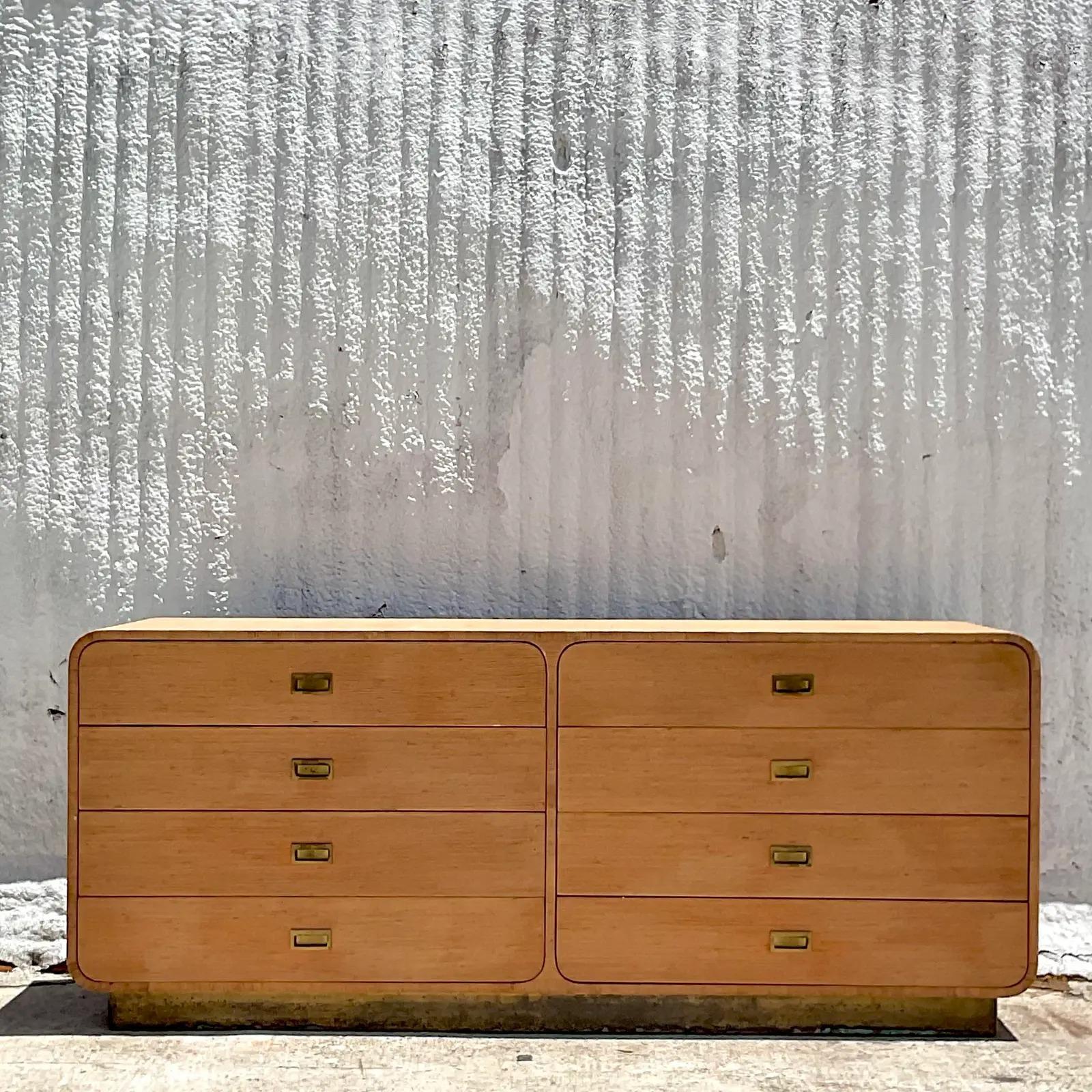 A fantastic vintage Coastal six drawer dresser. A Grasscloth cabinet with a chic waterfall design. Brass hardware and brass plinth. Acquired from a Palm Beach estate.
