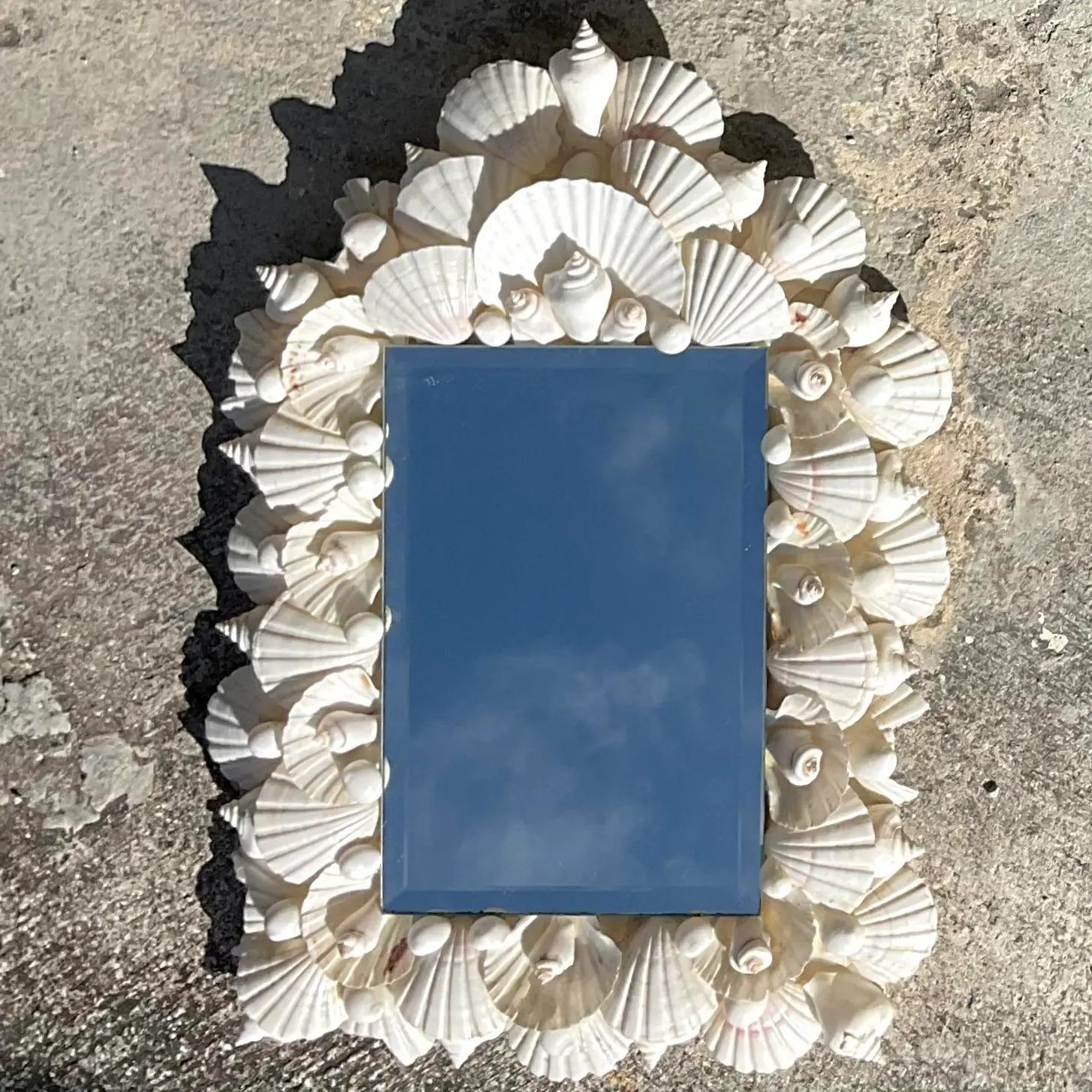 A fabulous vintage Coastal wall mirror. A classic handmade shell design in beautiful tonal shells. Acquired from a Palm Beach estate.