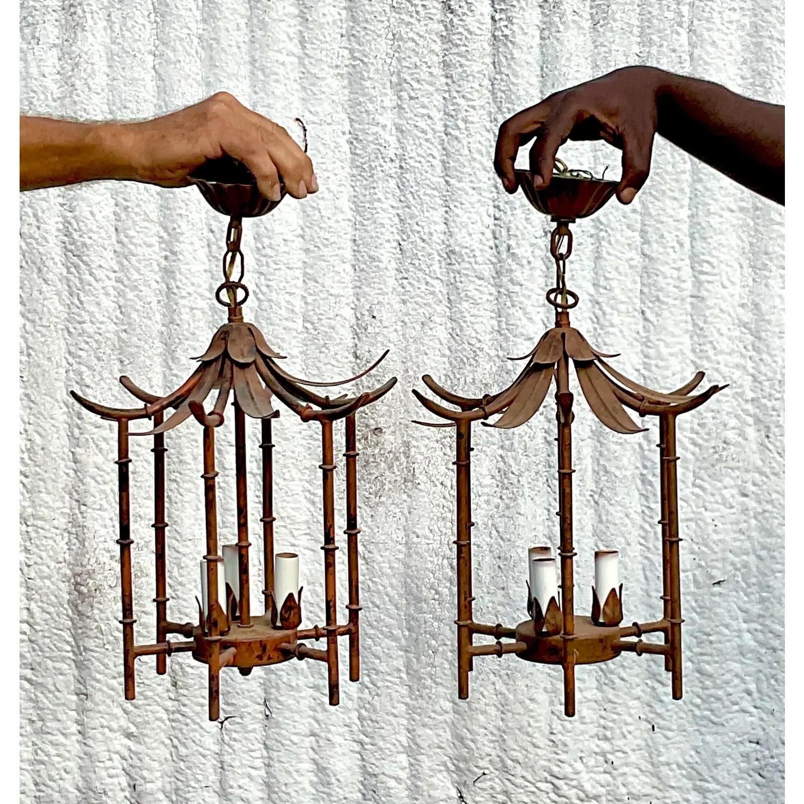 A fantastic pair of vintage Coastal pendant light fixtures. Spectacular cast bamboo pagoda lamps. Beautiful bamboo leaf roof. Just the most charming pair. Perfect as is or paint to suit. Acquired from a Palm Beach estate.
