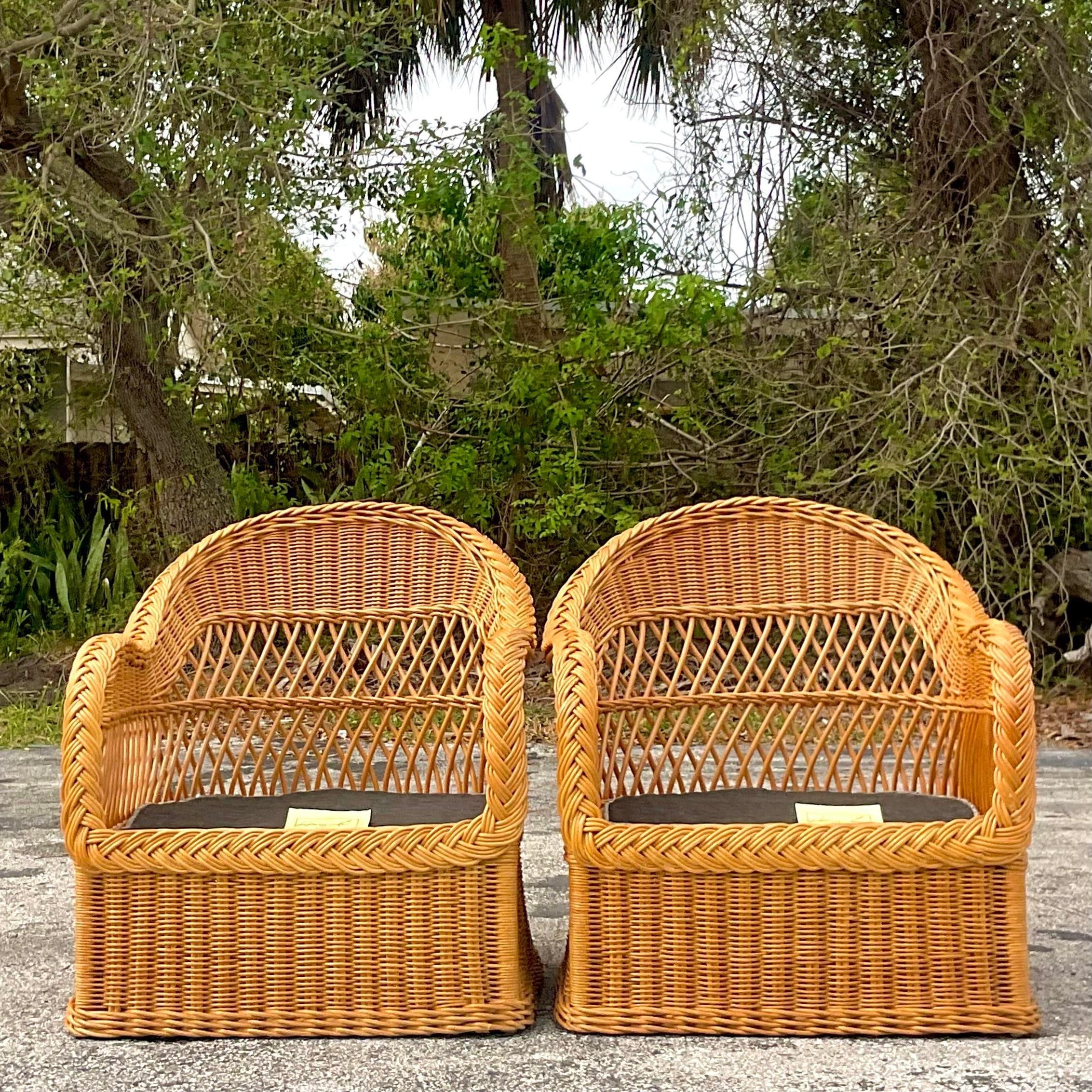 A fabulous pair of vintage Coastal lounge chairs. Made by the iconic Henry Link group and tagged on the seat. A chic braided rattan trim on a warm woven rattan acquired from a Palm Beach estate.