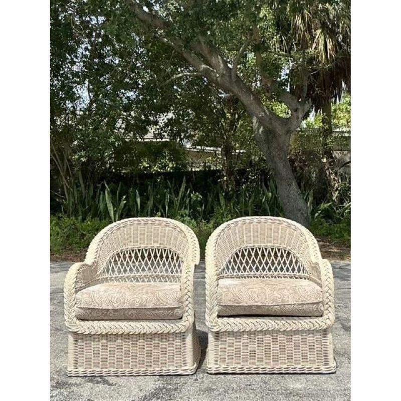 Drift into relaxed vintage style with this charming pair of Henry Link braided rattan lounge chairs, embodying the perfect blend of Coastal and Boho aesthetics. Renowned for their quality craftsmanship, Henry Link wicker and rattan pieces are