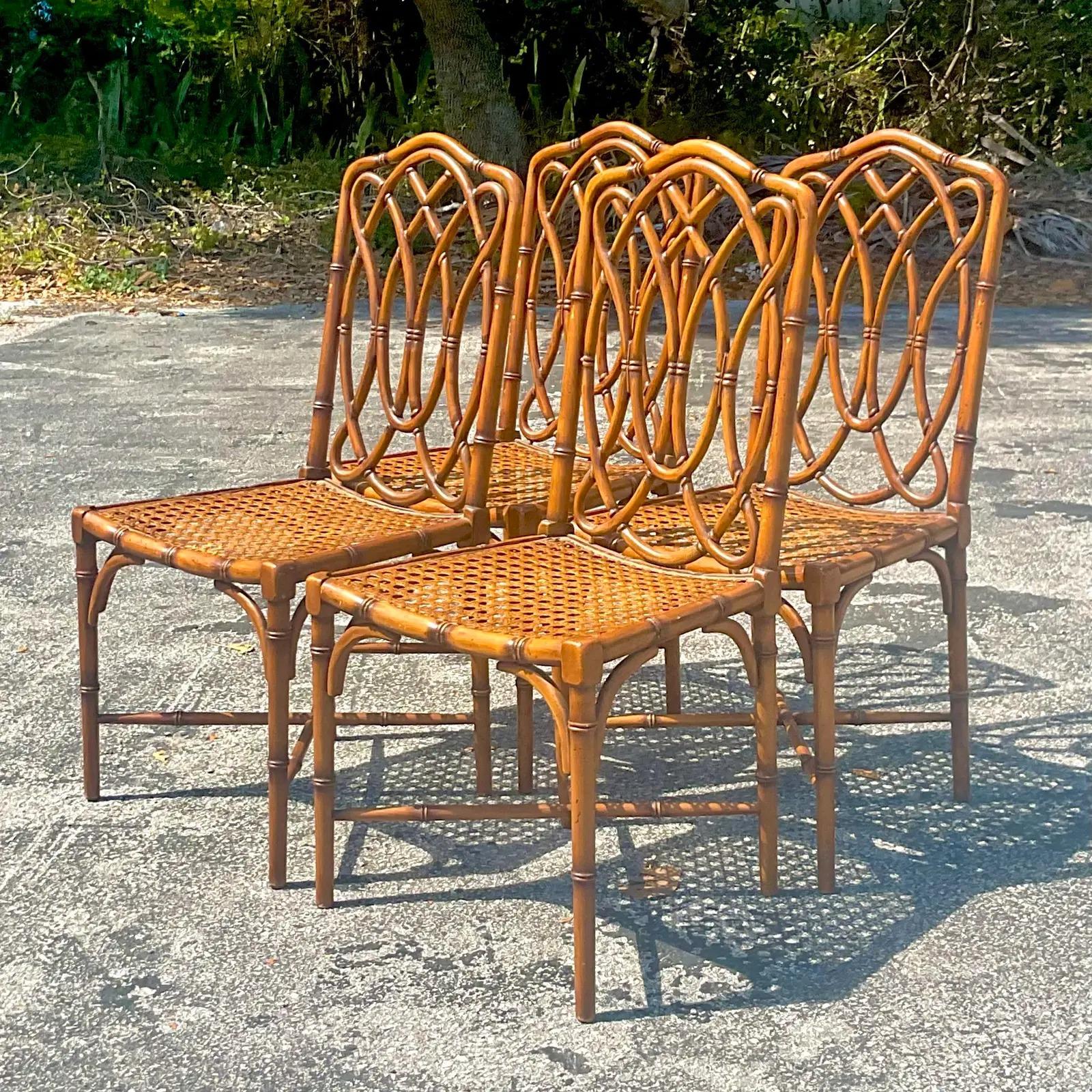 A spectacular set of four vintage coastal dining chairs. Beautiful carved bamboo frame with inset cane seats. Marked made in Italy on the bottom. Acquired from a Palm Beach estate.