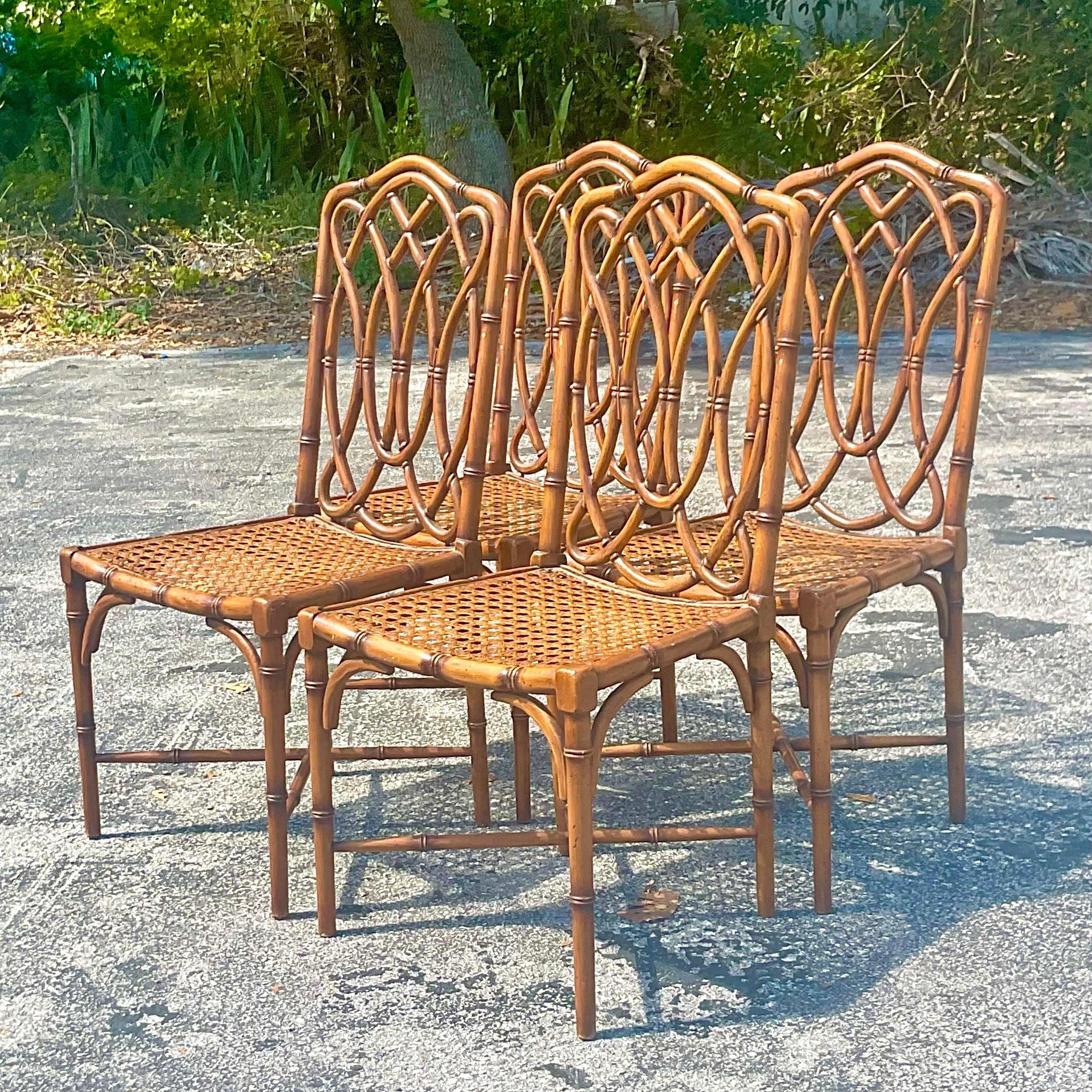 A spectacular set of four vintage coastal dining chairs. Beautiful carved bamboo frame with inset cane seats. Marked made in Italy on the bottom. Acquired from a Palm Beach estate.