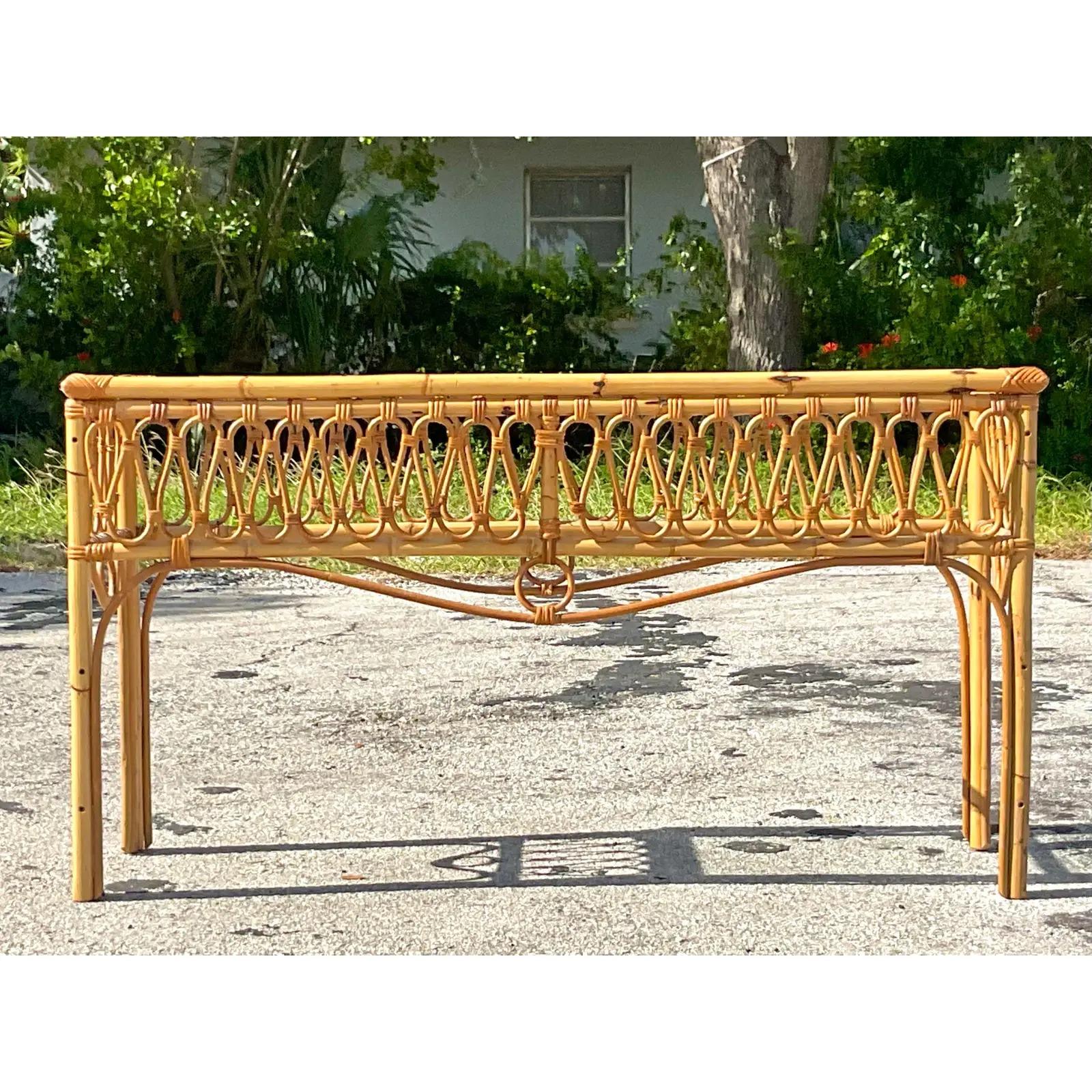 A fabulous vintage Coastal console table. A chic scrolling bent rattan border with an inset glass top. Perfect in its simplicity. Made in Italy. Acquired from a Palm Beach estate.