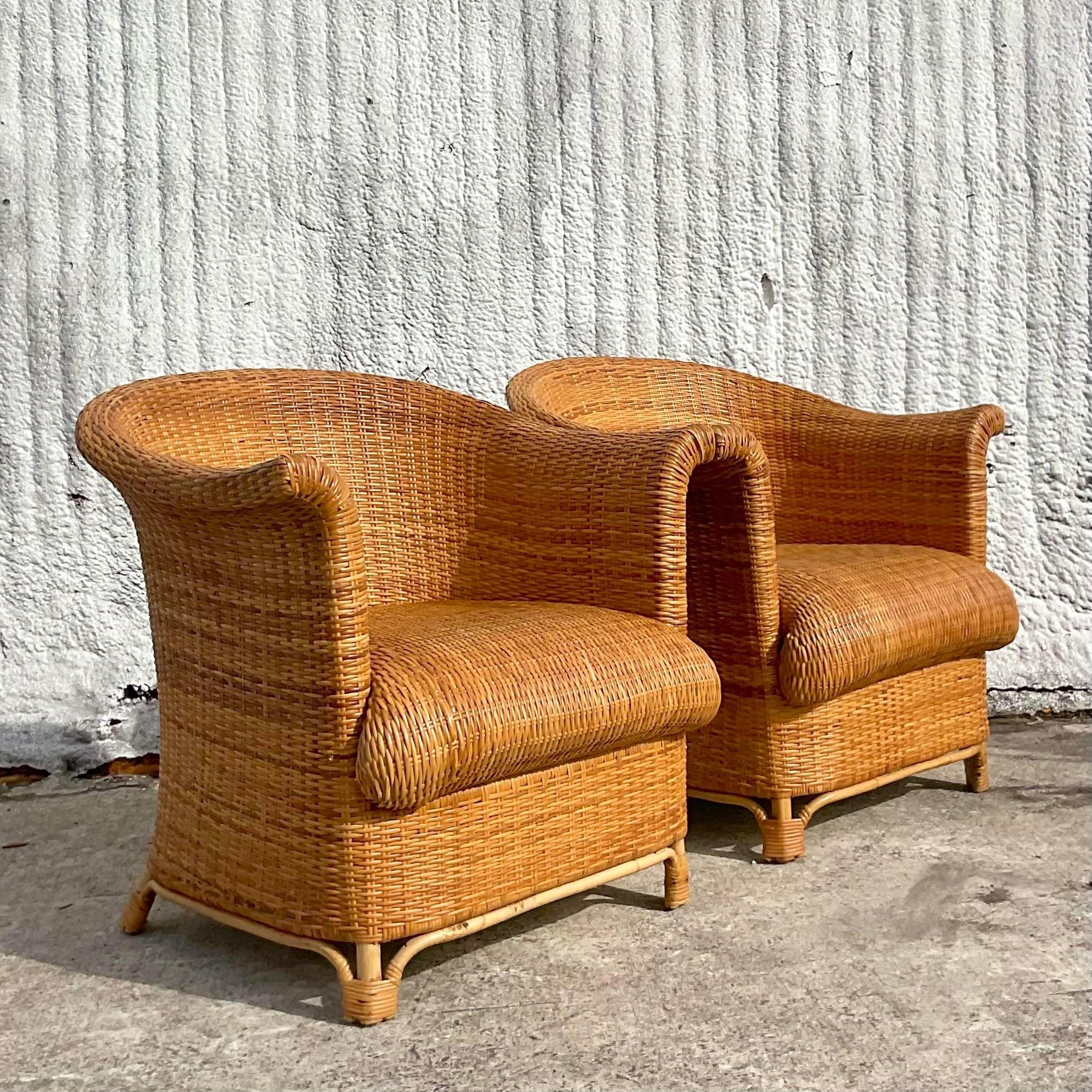 A stunning pair of vintage Italian Coastal club chairs. A chic all over woven rattan in a clean and modern shape. Matching ottomans also available on my  page. Acquired from a Palm Beach estate