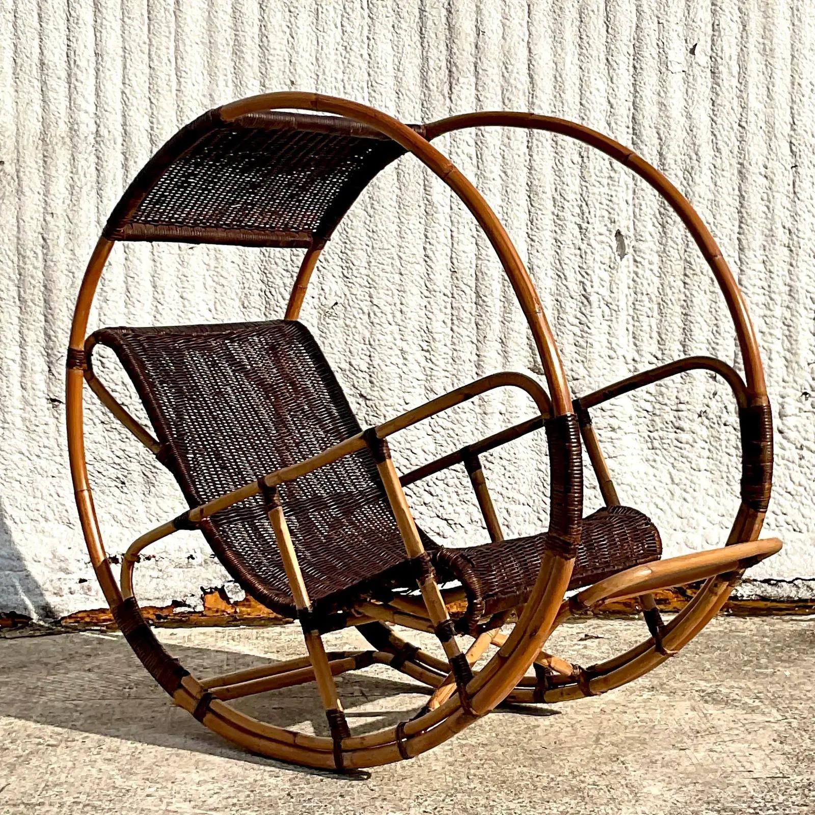 A fantastic vintage Coastal Italian wrapped rattan rocking chair. The “Donaldo” chair designed by Franco Bettonica. A chic bamboo frame with a woven rattan seat and canopy. Acquired from a Palm Beach estate.