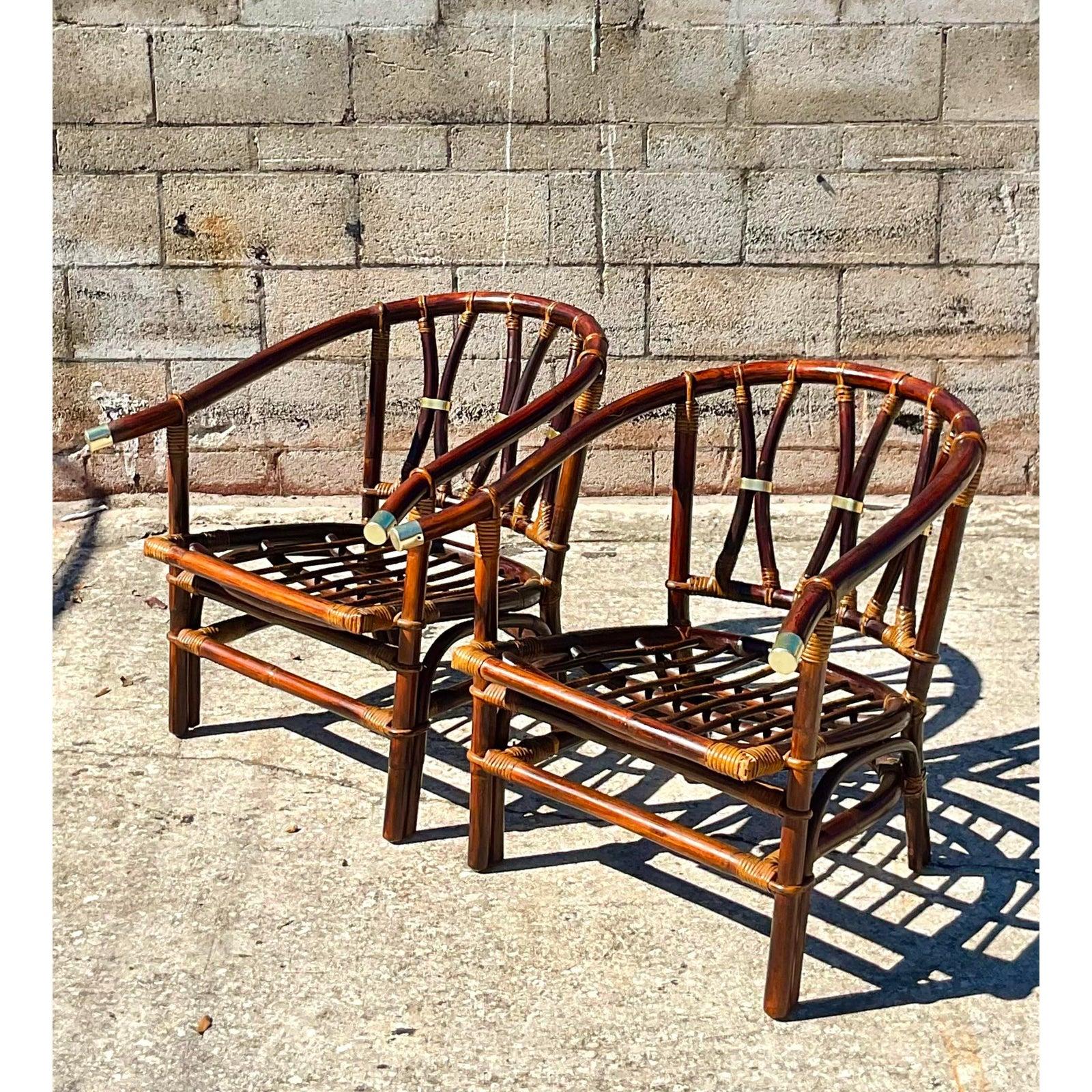 Fantastic pair of vintage Coastal Ficks Reed arm chairs. Made by the Iconic John Wisner and part of the coveted Far East collection. Chic brass hardware and deep rich brown make these a great addition to any décor. Acquired from a Palm Beach estate.