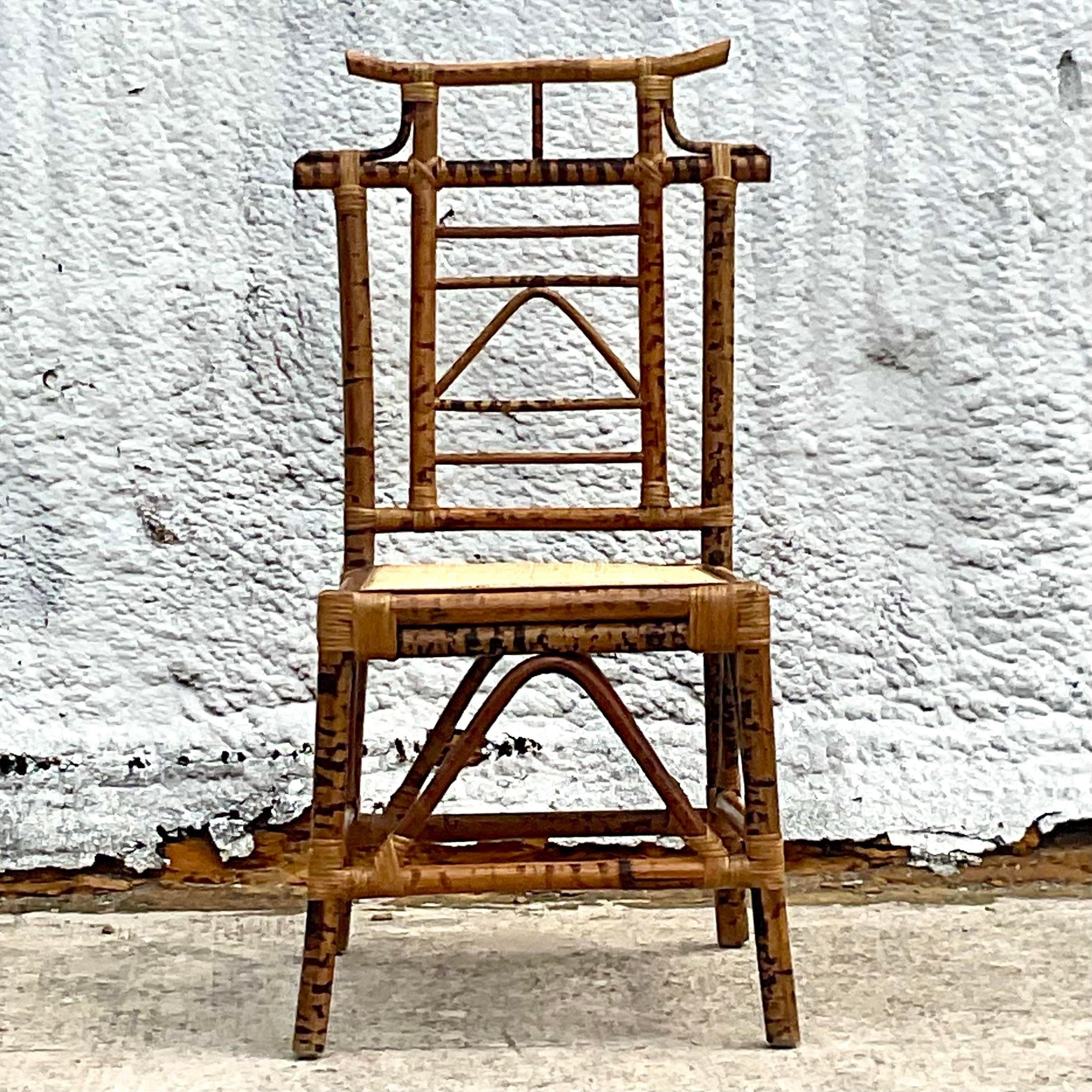 A fantastic vintage coastal chair. A chic Pagoda design in a burnt bamboo frame. Inset cane seat. handmade construction that makes it a little asymmetrical. Original to the design. Acquired from a Palm Beach estate.