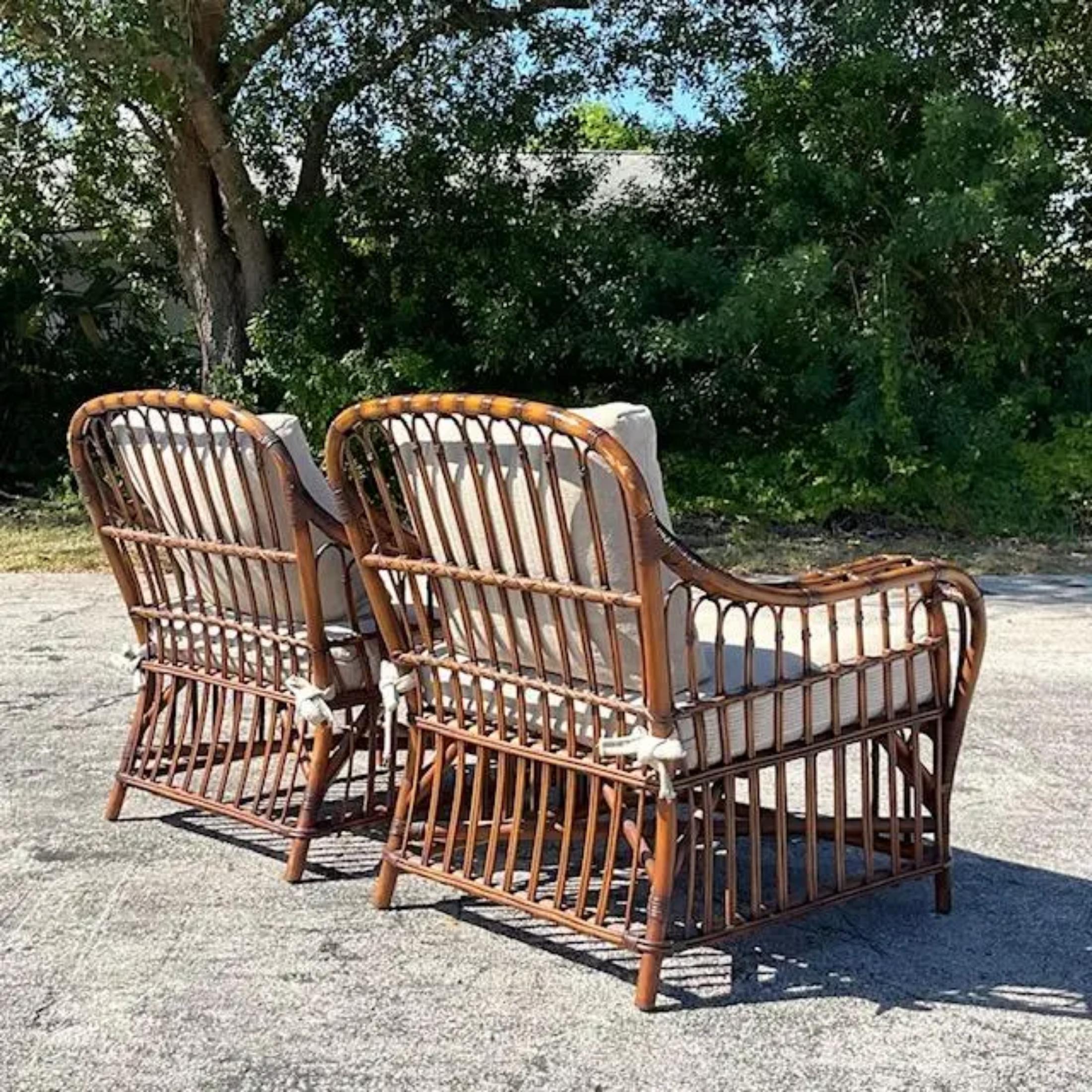A fabulous pair of vintage Coastal lounge chairs. A chic loop rattan design with deep wide seats. Done in the manner of the classic Bielecky Brothers. Acquired from a Palm Beach estate