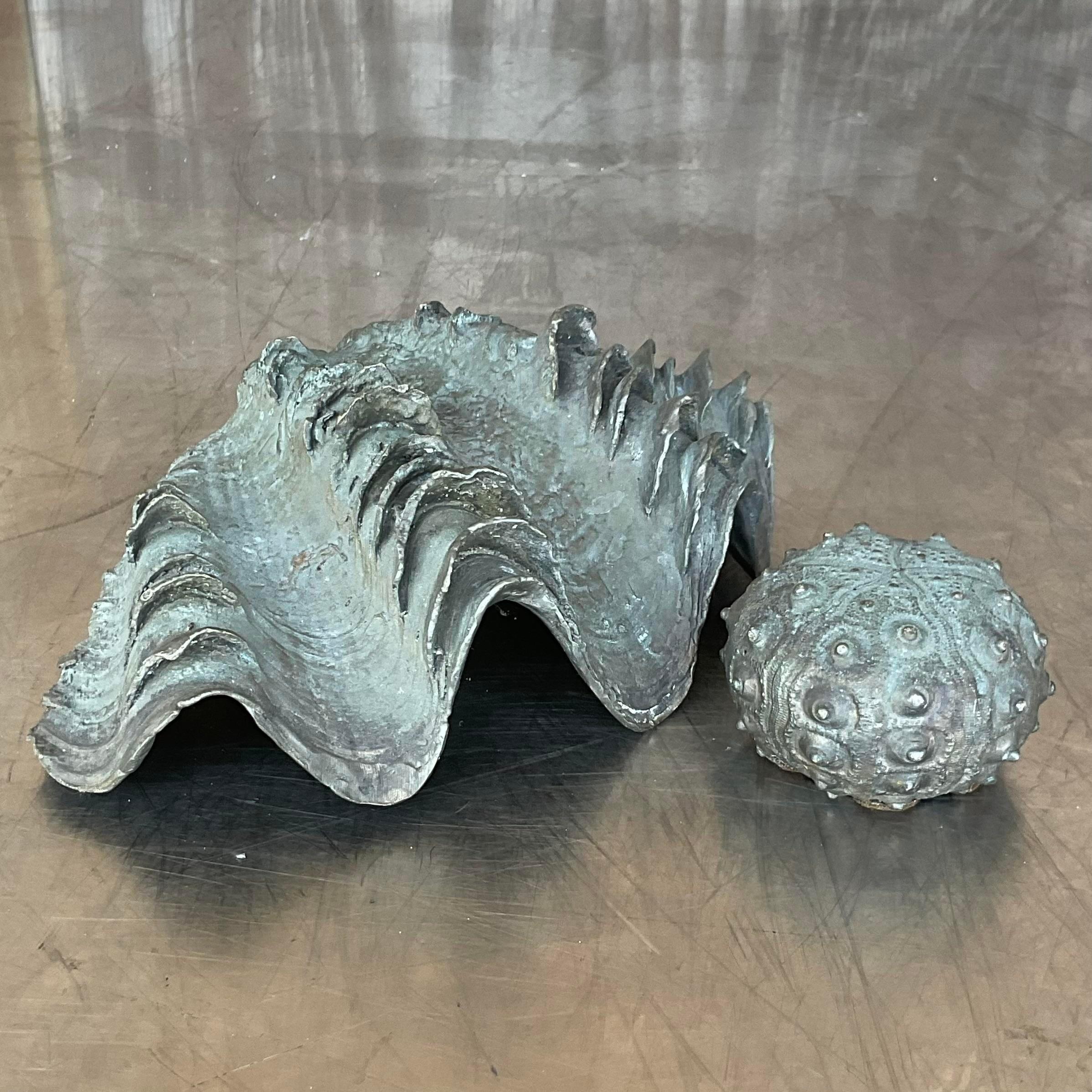 A striking vintage Coastal pair of sea creatures. Made by the iconic Maitland Smith. A bronze clam shell and his sea urchin friend. A great way to add a flash of glamour to any space. Acquired from a Palm Beach estate.
