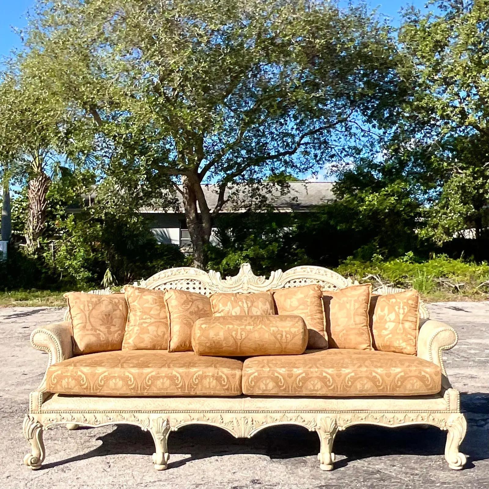 A fabulous vintage Regency hand carved sofa. Made by the iconic Maitland Smith group. Beautiful inset large cane panels in a deep seat shape. Marked on the bottom. Two sofas available as well for a striking pair. Acquired from a Palm Beach estate.