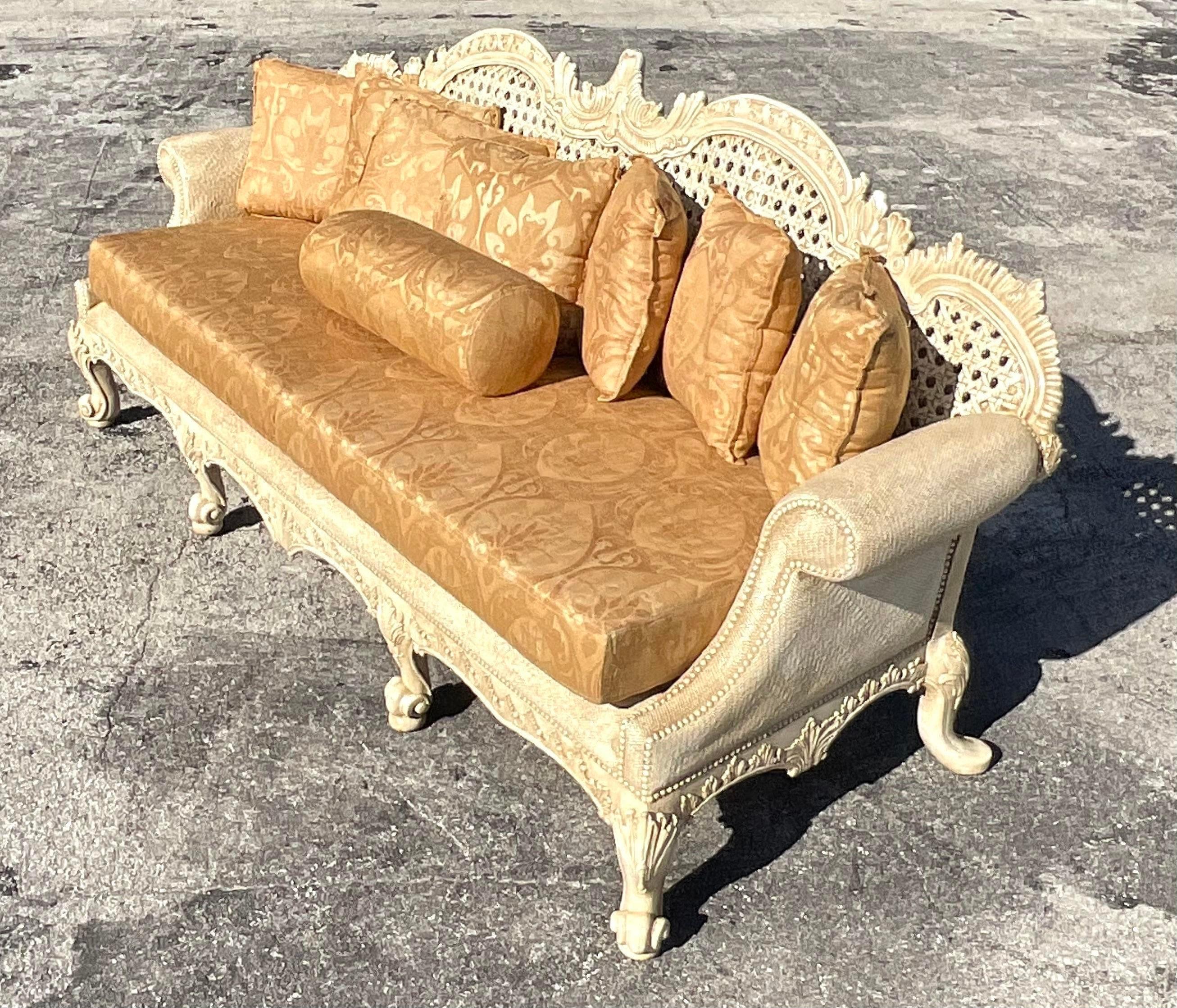 A fabulous vintage Regency hand carved sofa. Made by the iconic Maitland Smith group. Beautiful inset large cane panels in a deep seat shape. Marked on the bottom. Two sofas available as well for a striking pair. Acquired from a Palm Beach estate.