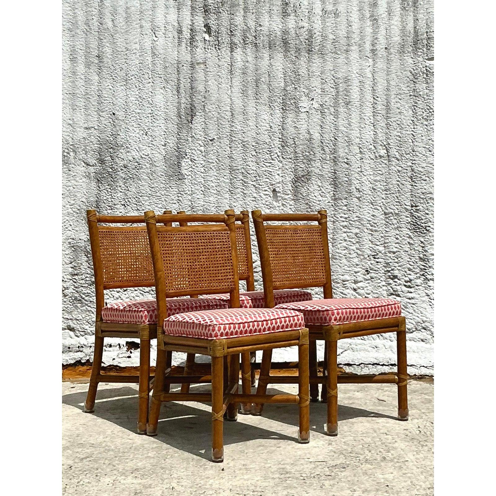 Aggiungi un fascino senza tempo e un'atmosfera costiera alla tua sala da pranzo con questo splendido set di quattro sedie da pranzo vintage con schienale in canna in stile McGuire. Realizzate con strutture in bambù dai toni caldi del miele e