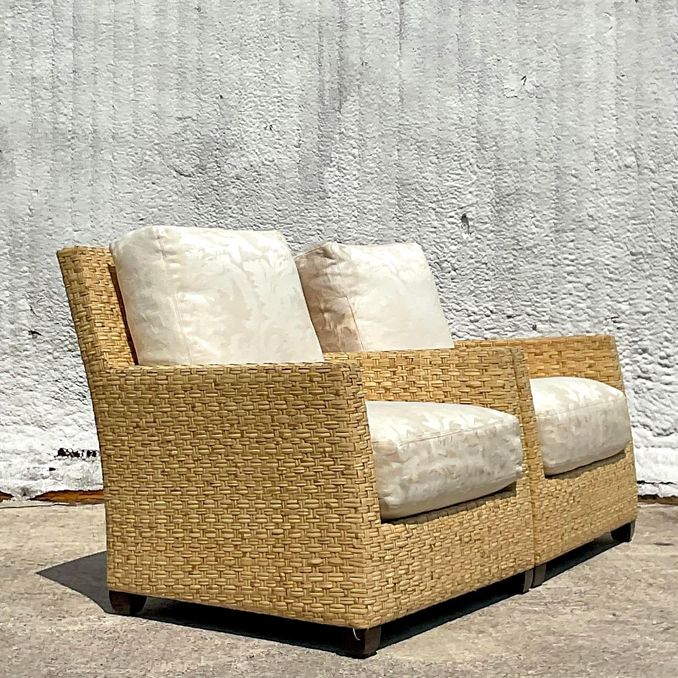 An extraordinary pair of vintage Coastal lounge chairs. Made by the iconic McGuire group and tagged on the bottom. A chic limited edition with a wide ribbon rattan and mahogany feet. Acquired from a Miami estate.
