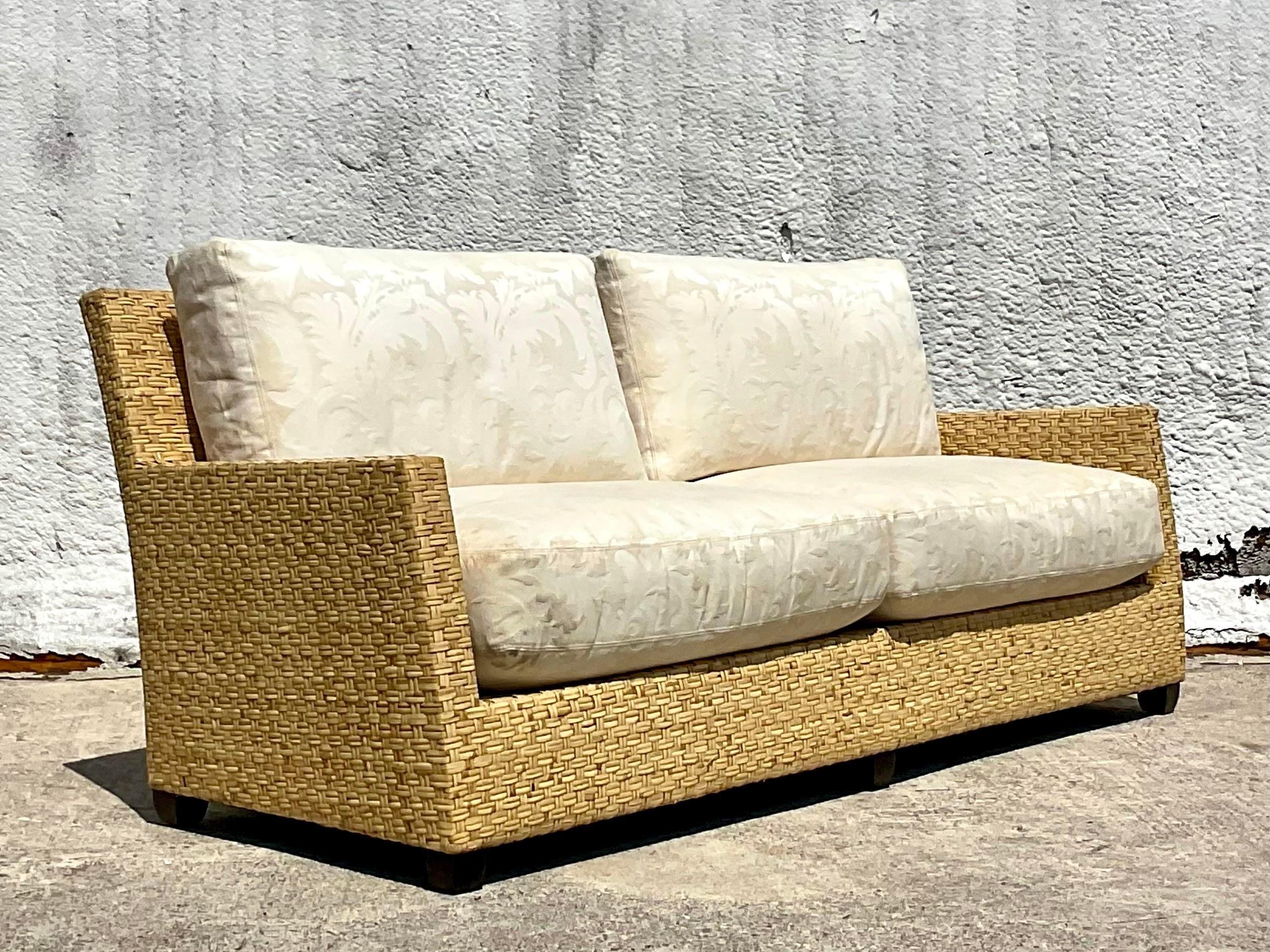 A stunning vintage Coastal sofa. Made by the iconic McGuire group. Chic wide ribbon rattan in a limited edition design. Acquired from a Palm Beach estate.