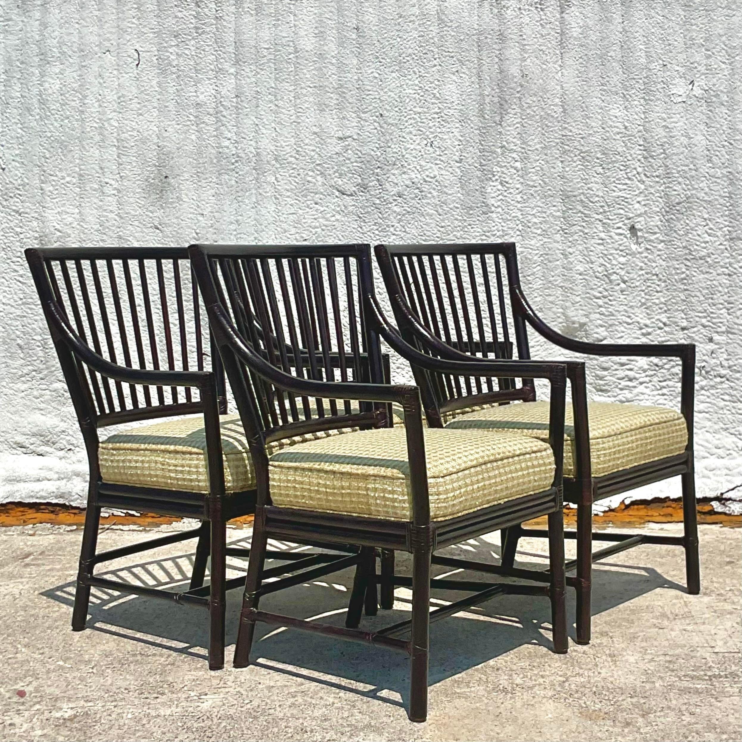 A fantastic set of four vintage Coastal slat back arm chairs. Made by the iconic McGuire group and tagged on the bottom. Chic bent rattan in an ebony finish. A pale green tweedy boucle upholstery. Acquired from a Miami estate.