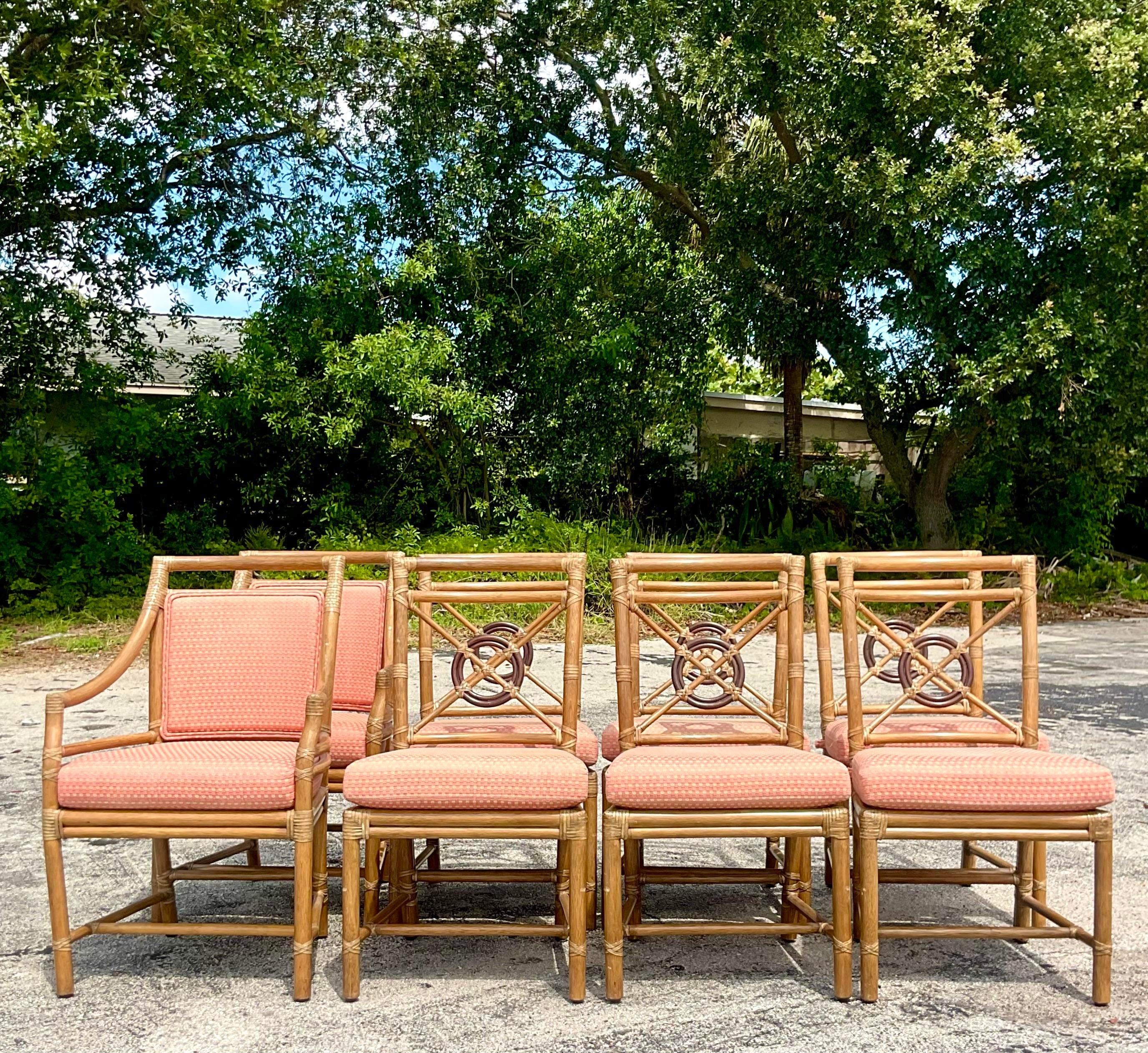 A stunning set of 8 vintage Coastal dining chairs. Made by the iconic McGuire group. Their highly coveted Target back design. Tagged below the seat. Two arms and six sides. Acquired from a Palm Beach estate.

Armchair - 24x17.5x36.
