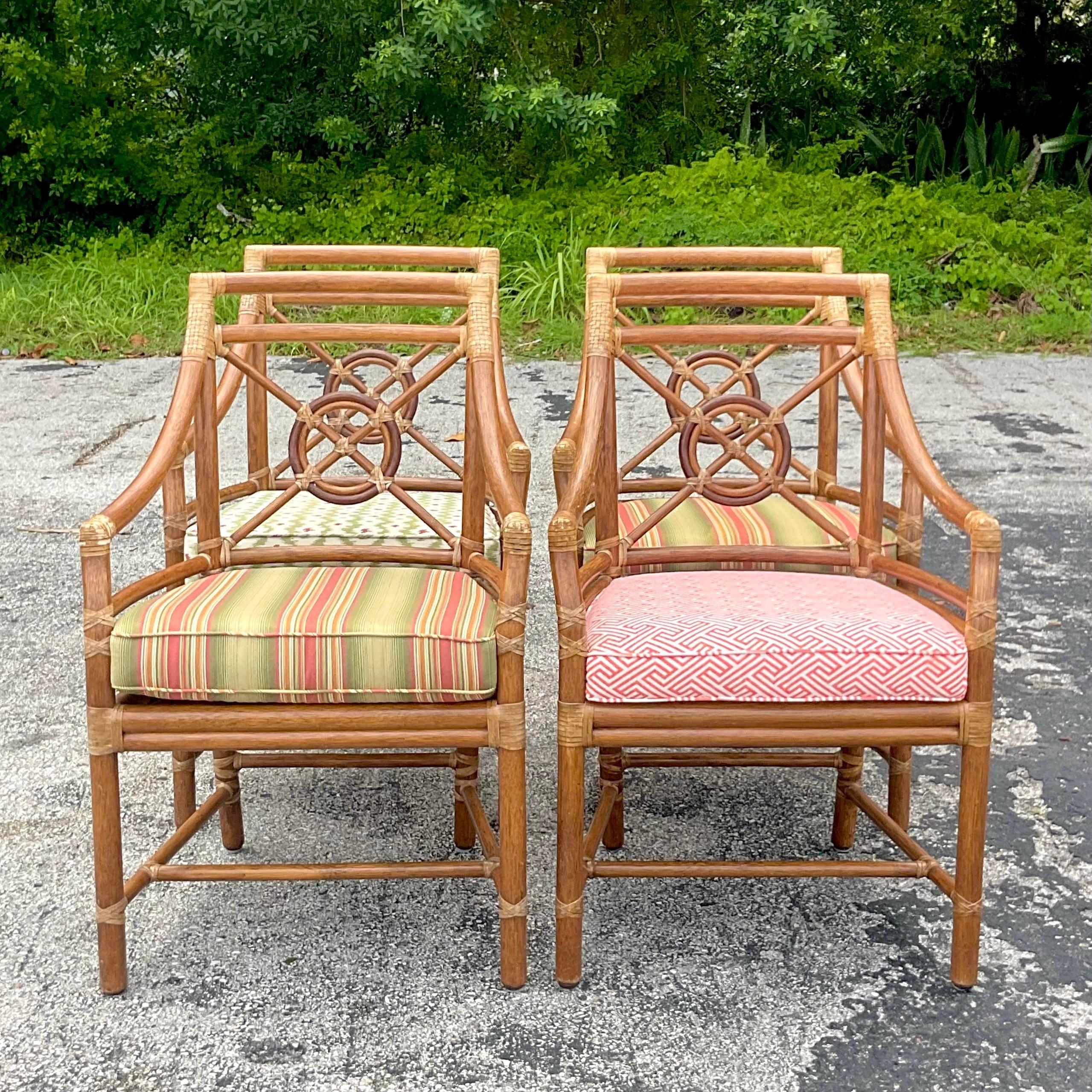 Vintage Coastal Rattan dining chairs. Made by the iconic McGuire group and tagged on the bottom. The coveted Target back design. Chic loose cushions in four different, but coordinating upholstery. Acquired from a Palm Beach estate