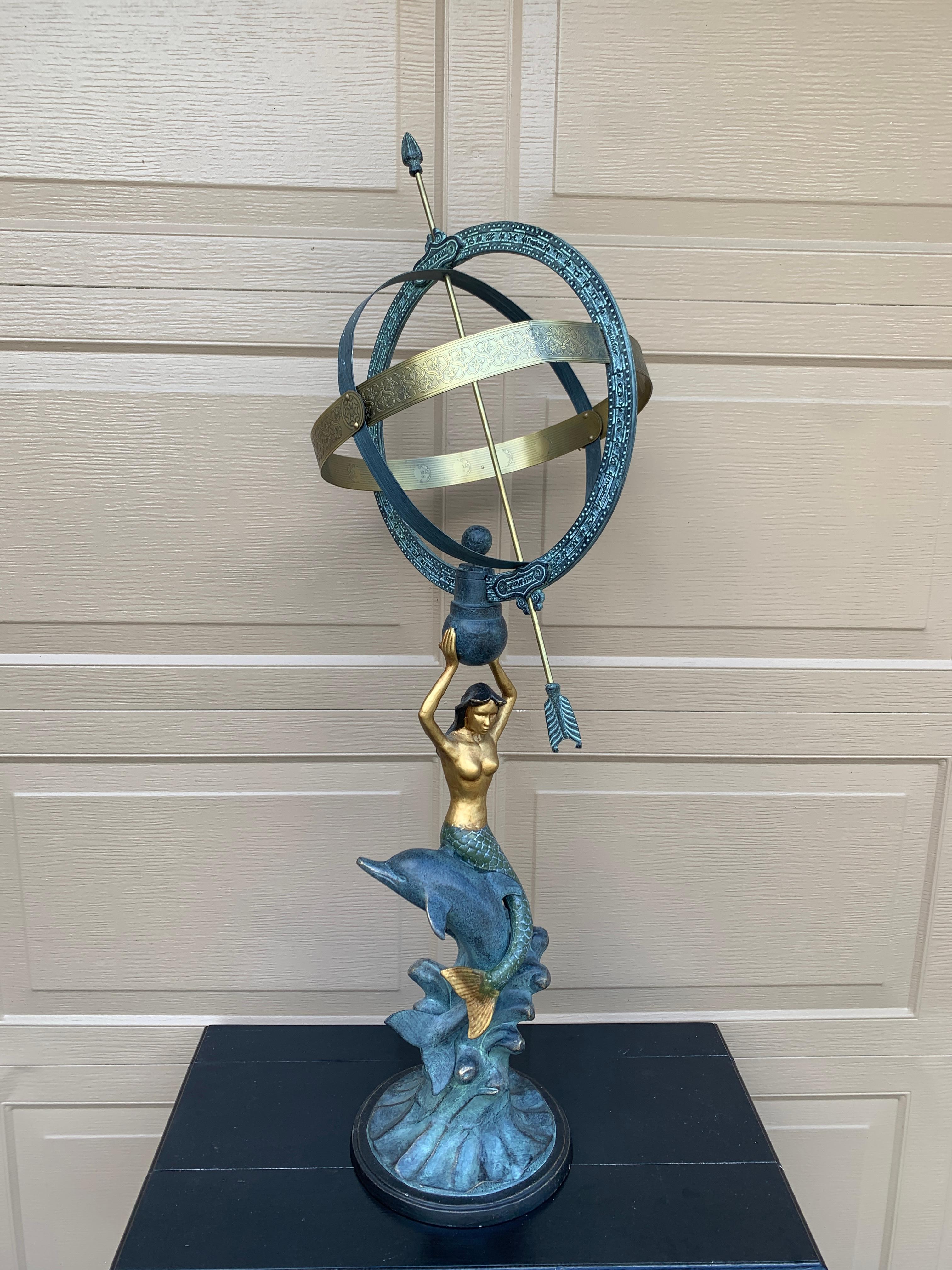 A stunning vintage coastal garden armillary sundial featuring a mermaid perched on a dolphin. Perfect for your Palm Beach or coastal home!

USA, Late 20th Century

Beautiful cast metal, in a patinated green color with gold accents

Measures: 13.75