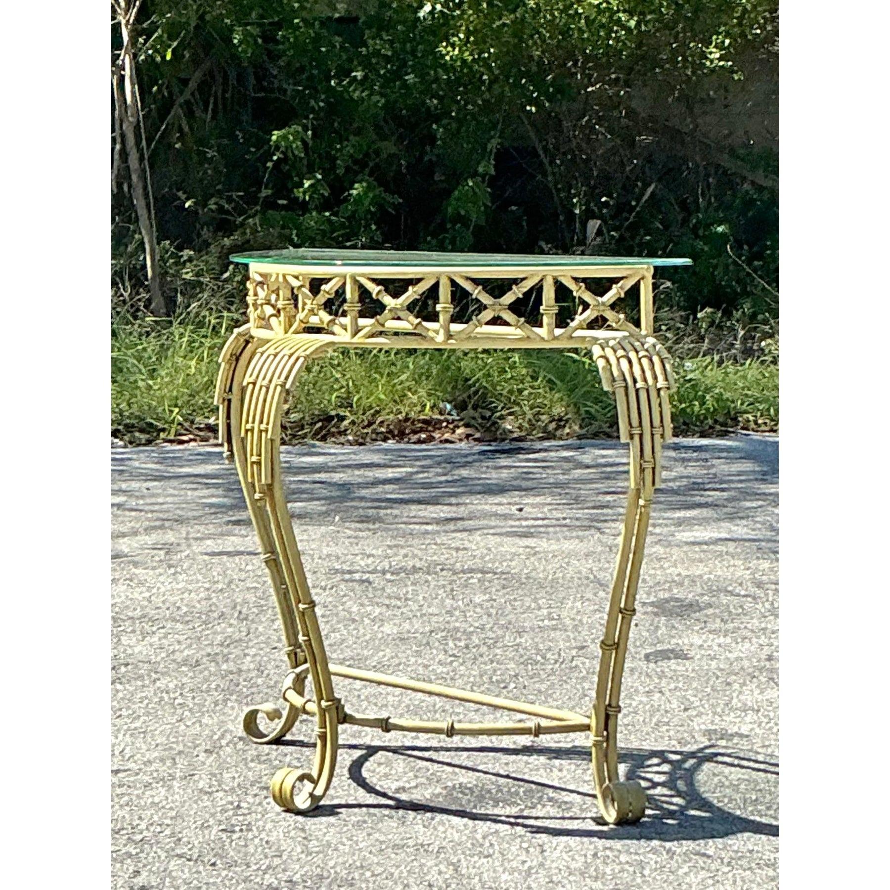 Ajoutez une touche d'élégance tropicale à votre espace avec cette table demilune vintage côtière en métal et bambou. Fabriquée avec un design en faux bambou et une silhouette démilune incurvée, cette table exsude une sophistication sans effort. Les