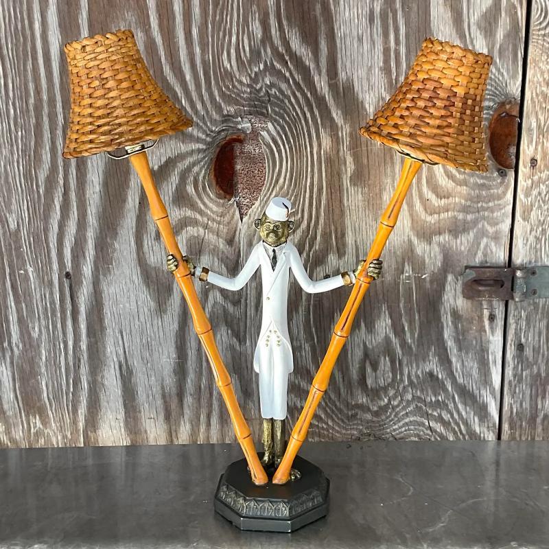 A fabulous vintage Coastal table lamp. A handsome monkey in a suit and fez. He is holding on to two bamboo branches. Acquired from a Palm Beach estate