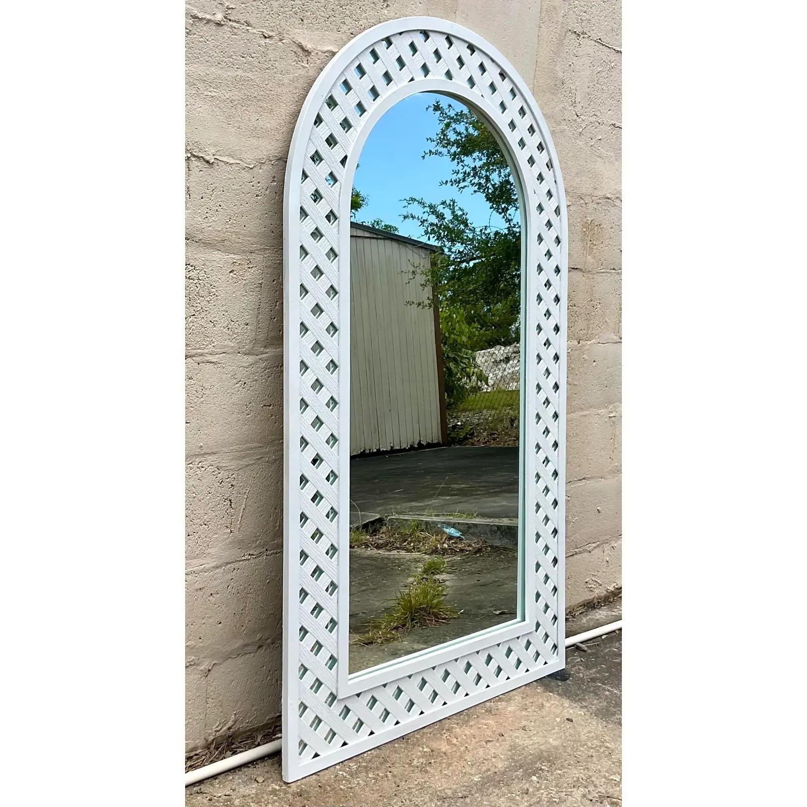 Fantastic vintage Coastal mirror. Beautiful arched design with a classic trellis treatment. Painted a chic plaster white. Acquired from a Palm Beach estate.