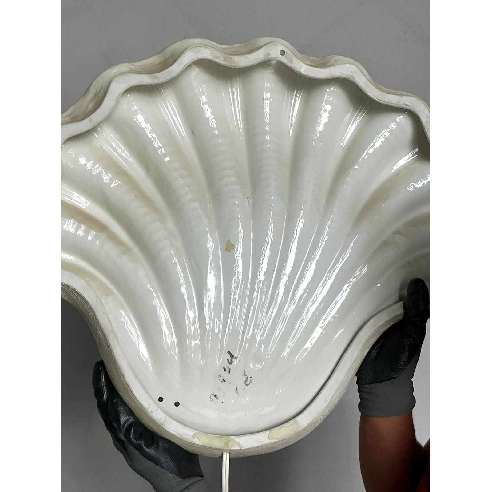 Eleg évoque l'élégance sereine du bord de mer avec cette exceptionnelle applique murale vintage à coquille. Fabriquée dans les années 1970, cette pièce monumentale capture la beauté organique d'une coquille de palourde naturelle, réimaginée en