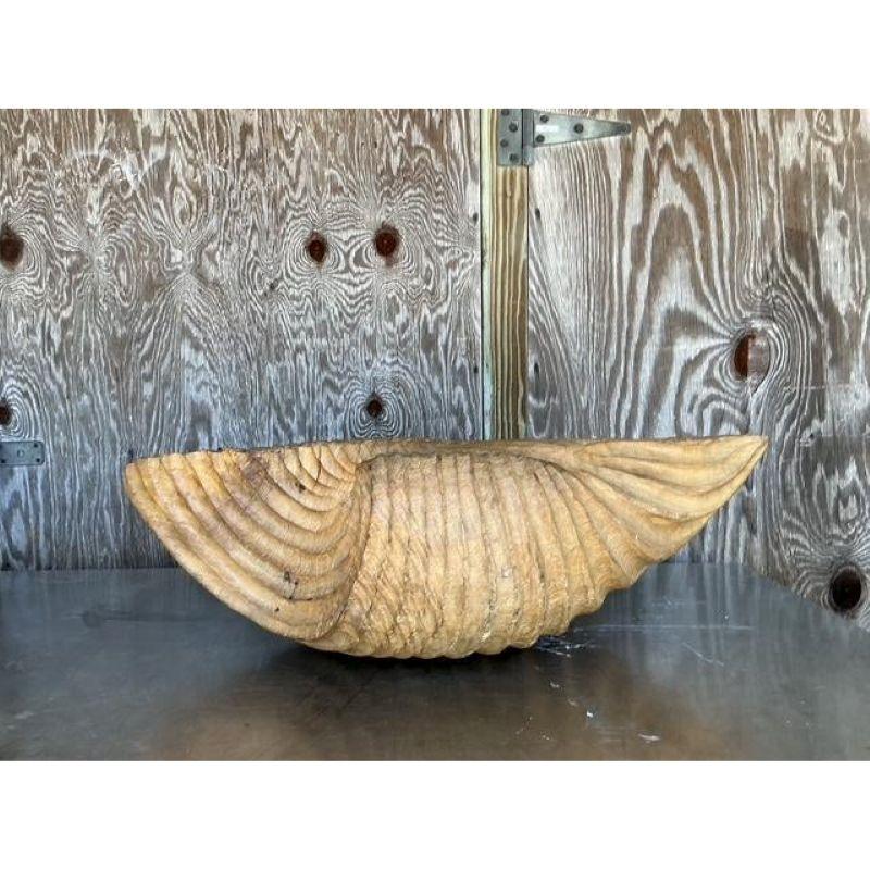Bring a powerful force of nature into your interior with this magnificent, large-scale clam shell bowl. Masterfully hand-carved from a substantial piece of wood, this monumental sculpture captures the organic form of a giant Tridacna gigas shell.