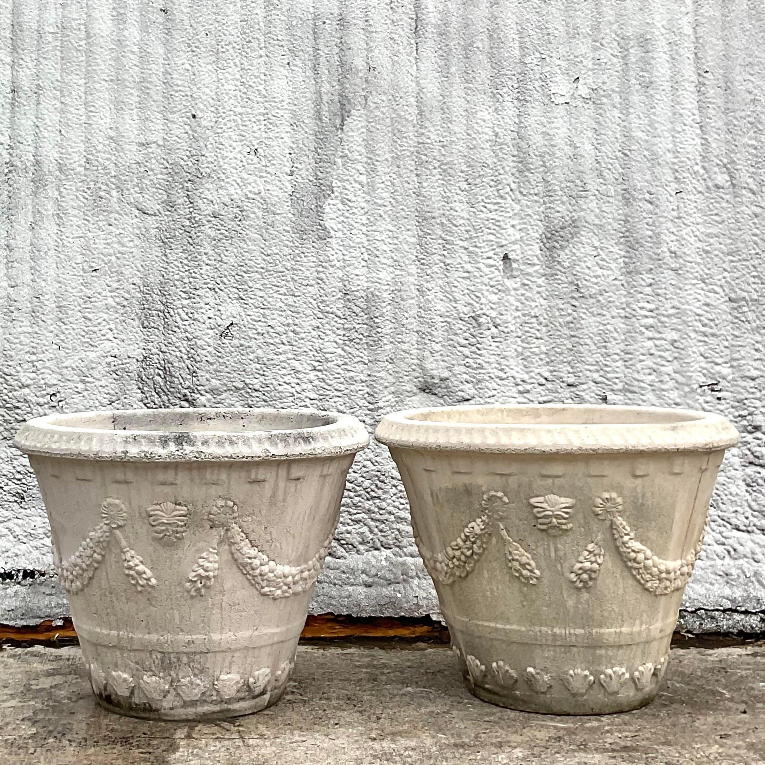 A striking pair of vintage Coastal planters. A chic swag garland design in a pale oyster finish. Monumental in size and frame. Perfect indoors or poolside. You decide! Acquired from a Palm Beach estate.