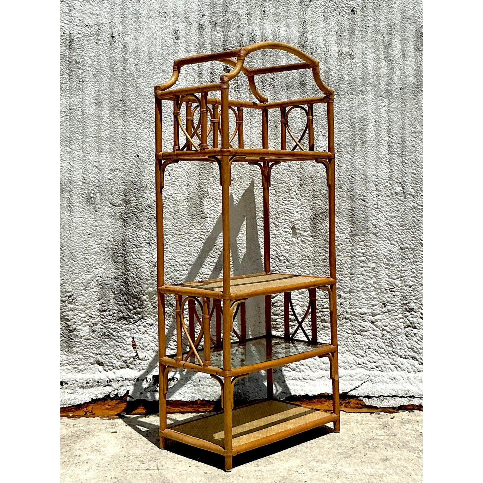 Capturez l'essence de l'élégance côtière avec cette étonnante étagère vintage en rotin et bambou, qui se distingue par son sommet arqué gracieusement entaillé. Cette pièce magnifiquement fabriquée met en valeur l'art du rotin courbé et du bambou.
